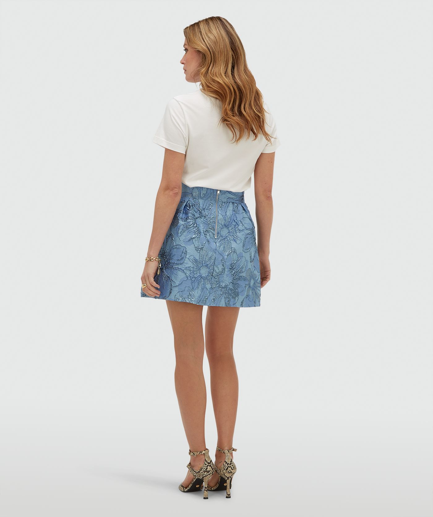 Achterzijde van een model in een high waisted rok met metallic details in de kleur Fresh Blue