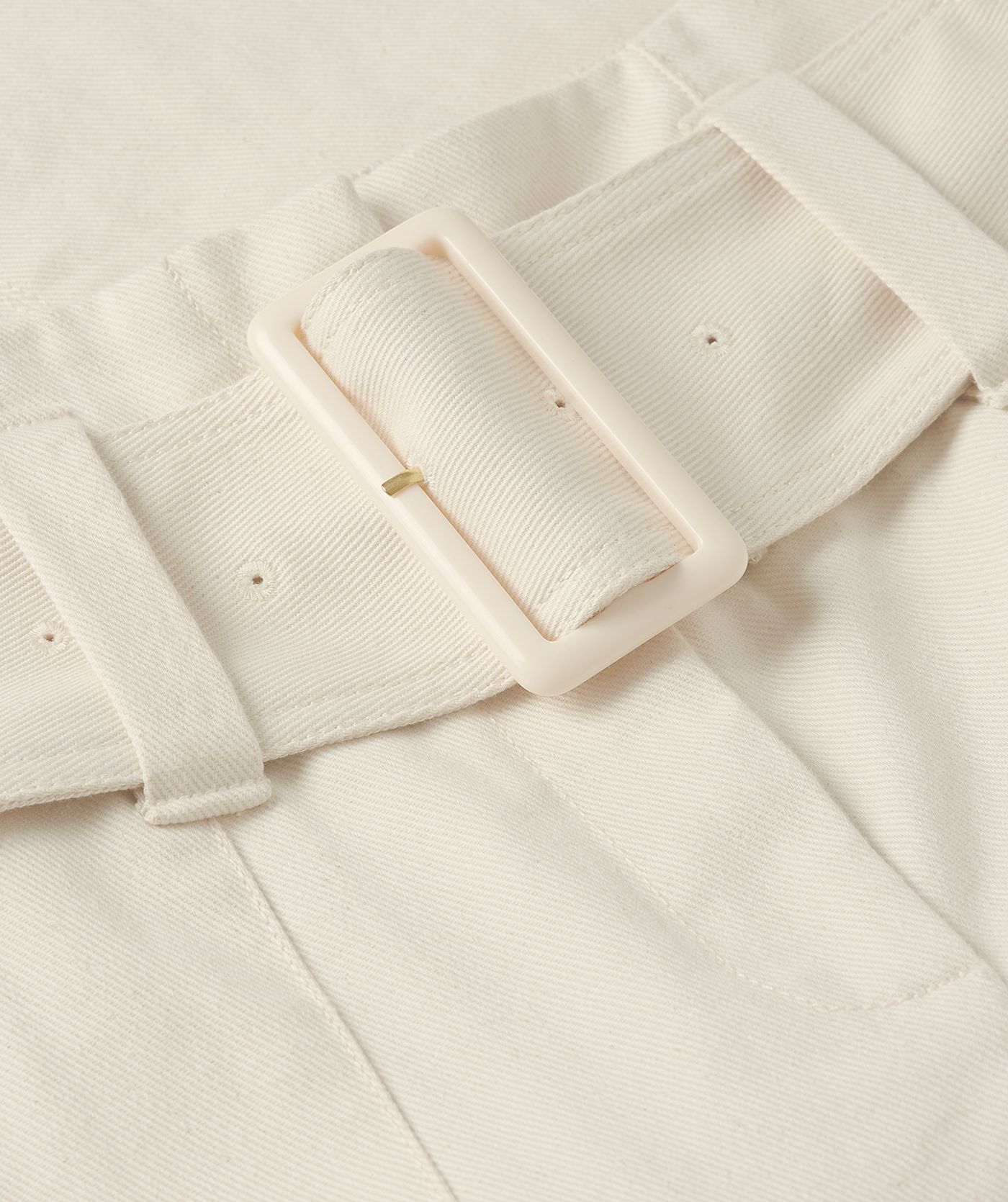 Close-up van de brede riem die bij de jeans zit.