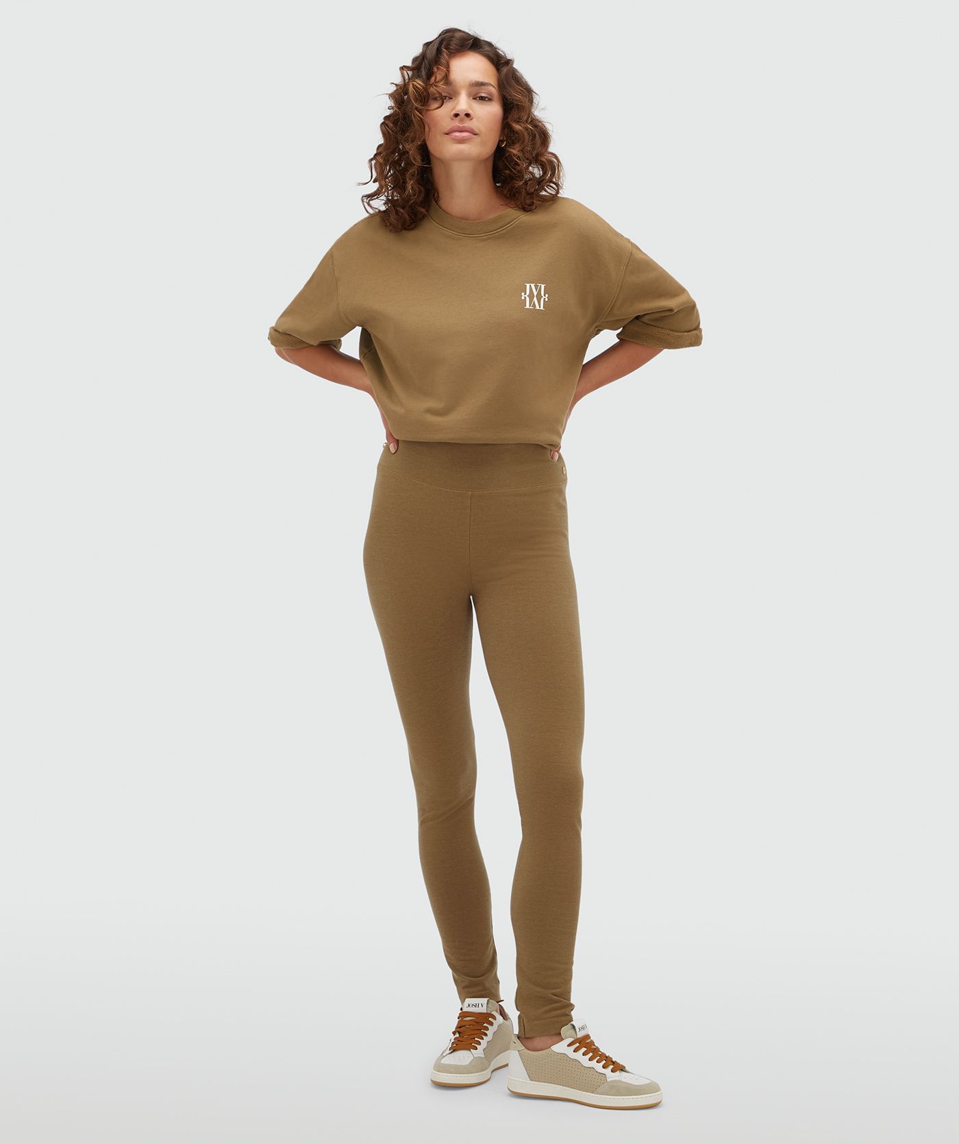 Model draagt een strakke lagging in de kleur Khaki gecombineerd met een sweater met korte mouwen.