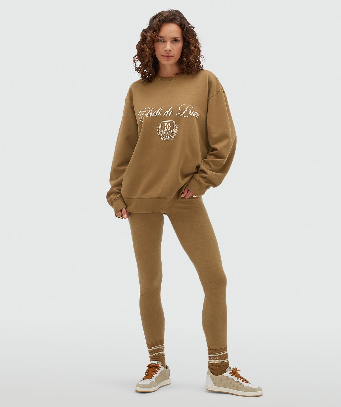 Model draagt een strakke lagging in de kleur Khaki gecombineerd met een sweater met korte mouwen.
