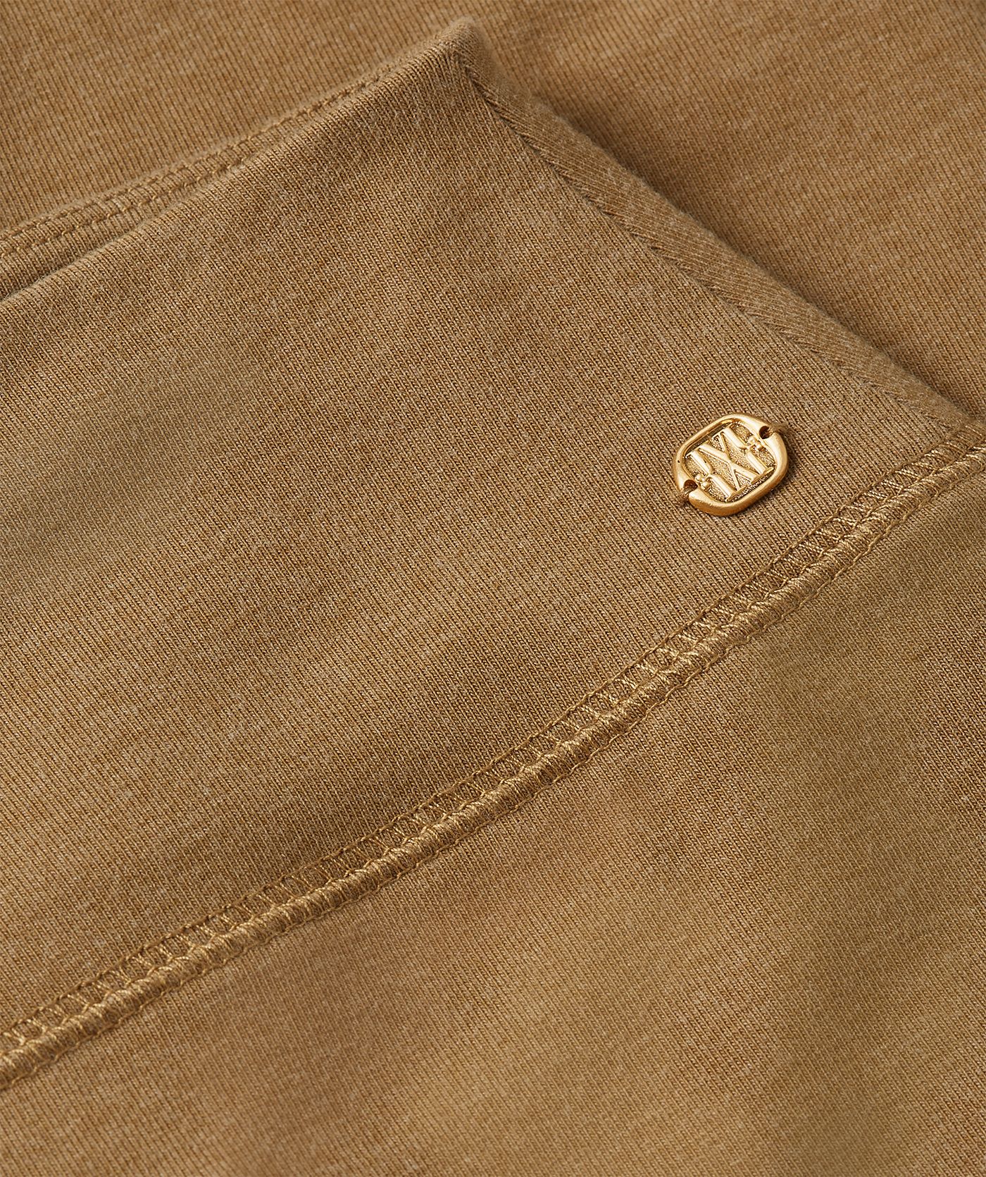 Close-up van het gouden JOSH V-logo aan de zijkant van de legging.