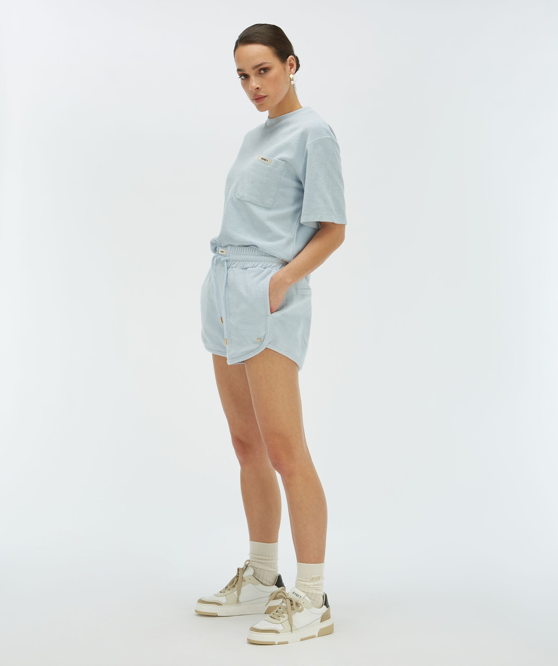 Model van opzij in een lichtblauwe short van zachte badstof, gedragen door een model - Josh V.