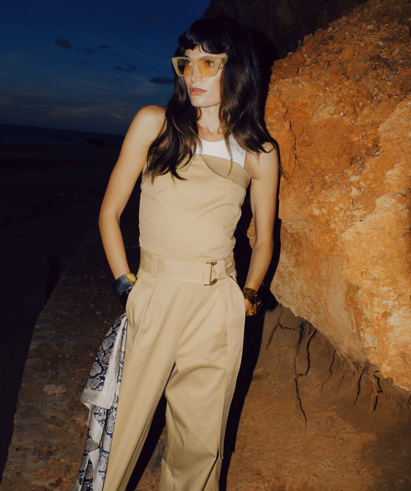 Model draagt een wide leg jumpsuit in de kleur Light Camel met een gespdetail in de taille