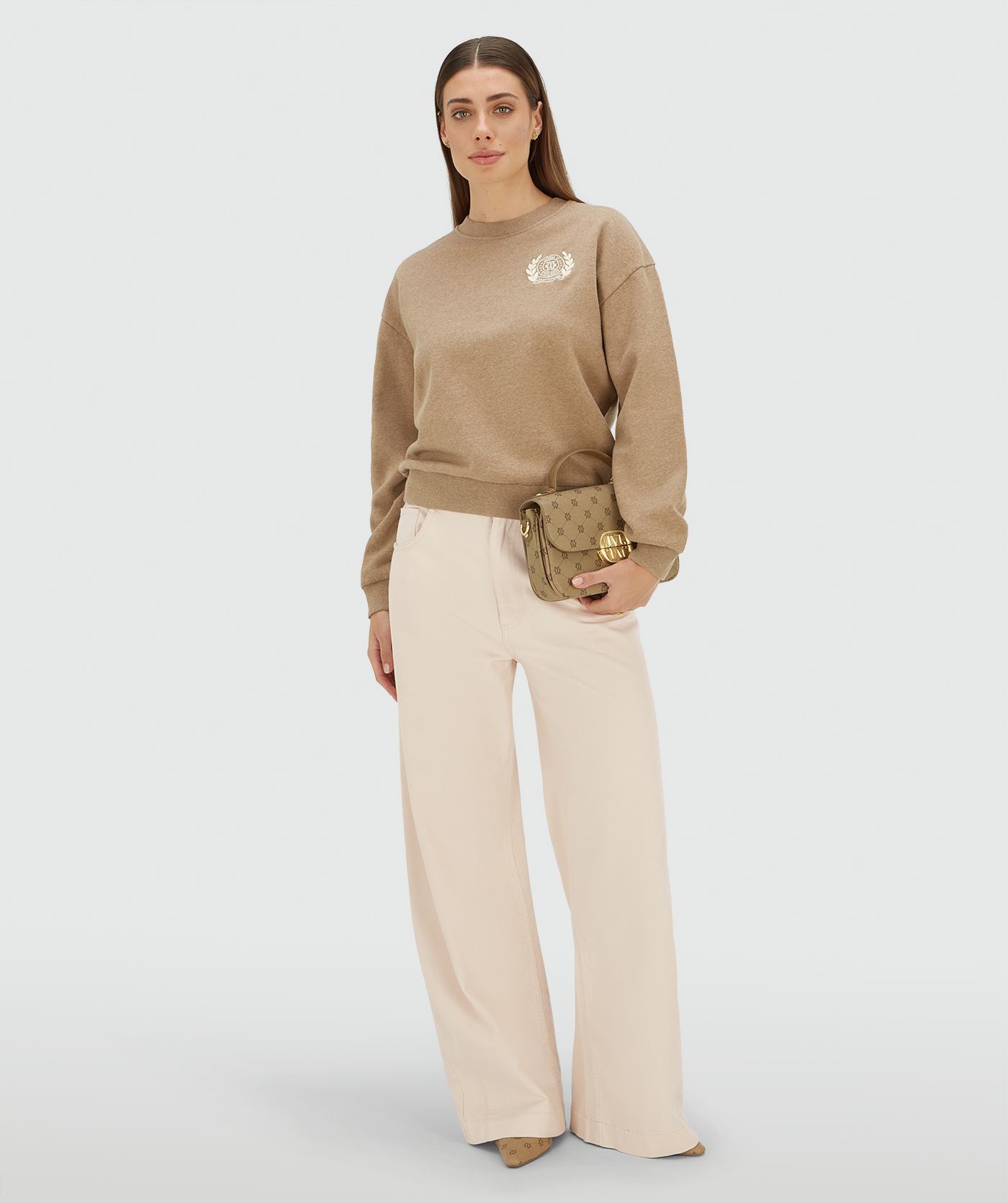 Model draagt een relaxed fit sweater met logo in de kleur Light Khaki Melange