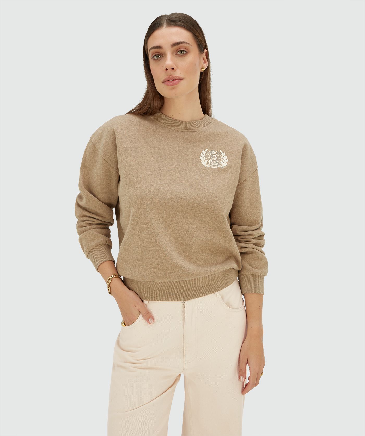 Model draagt een relaxed fit sweater met logo in de kleur Light Khaki Melange