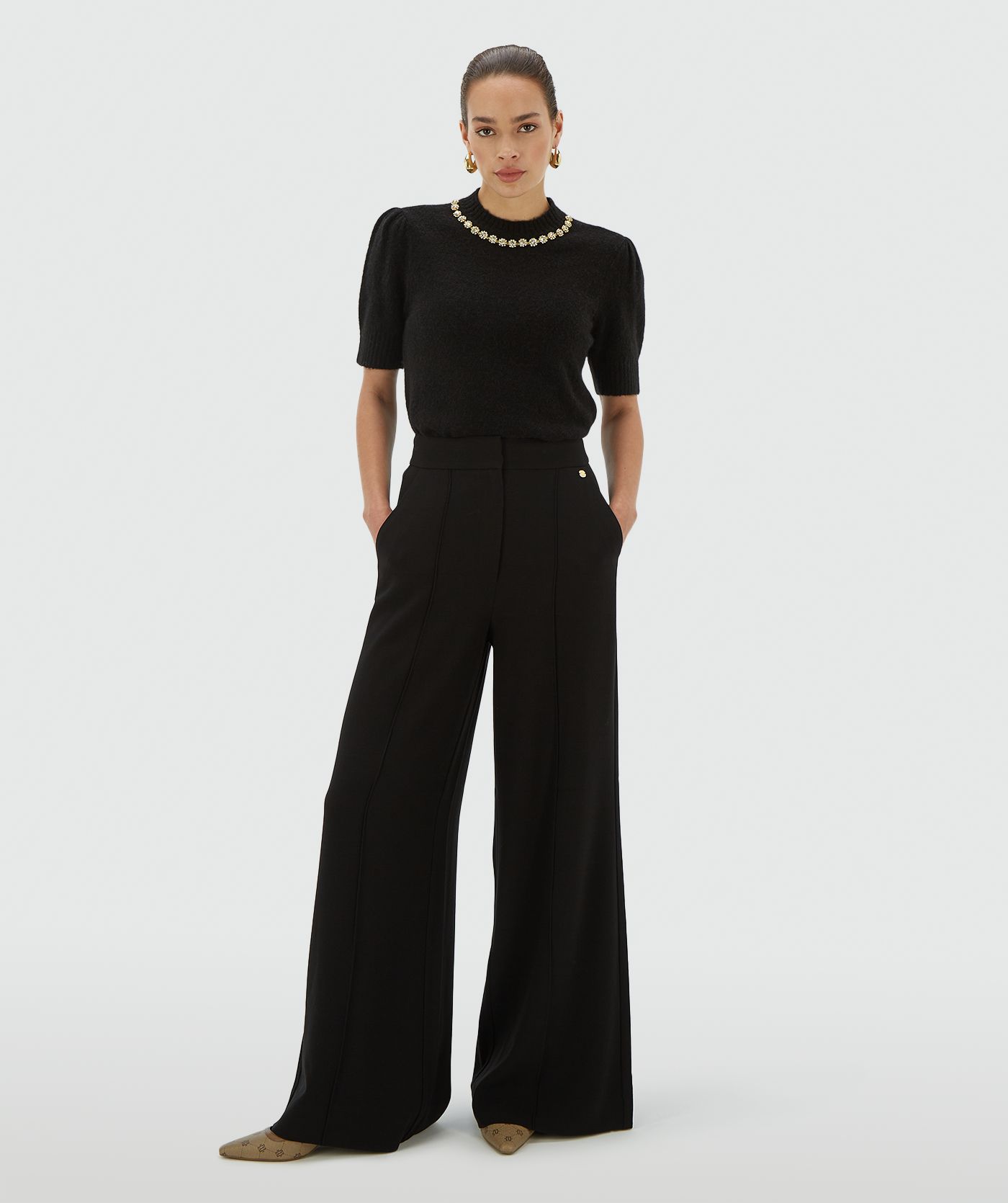 Model draagt een zwarte high waisted wide leg pantalon - Josh V