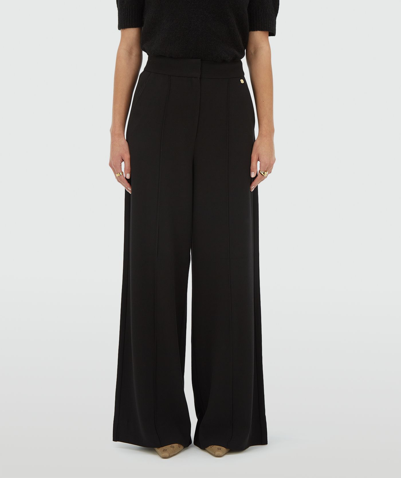 Model draagt een zwarte high waisted wide leg pantalon - Josh V