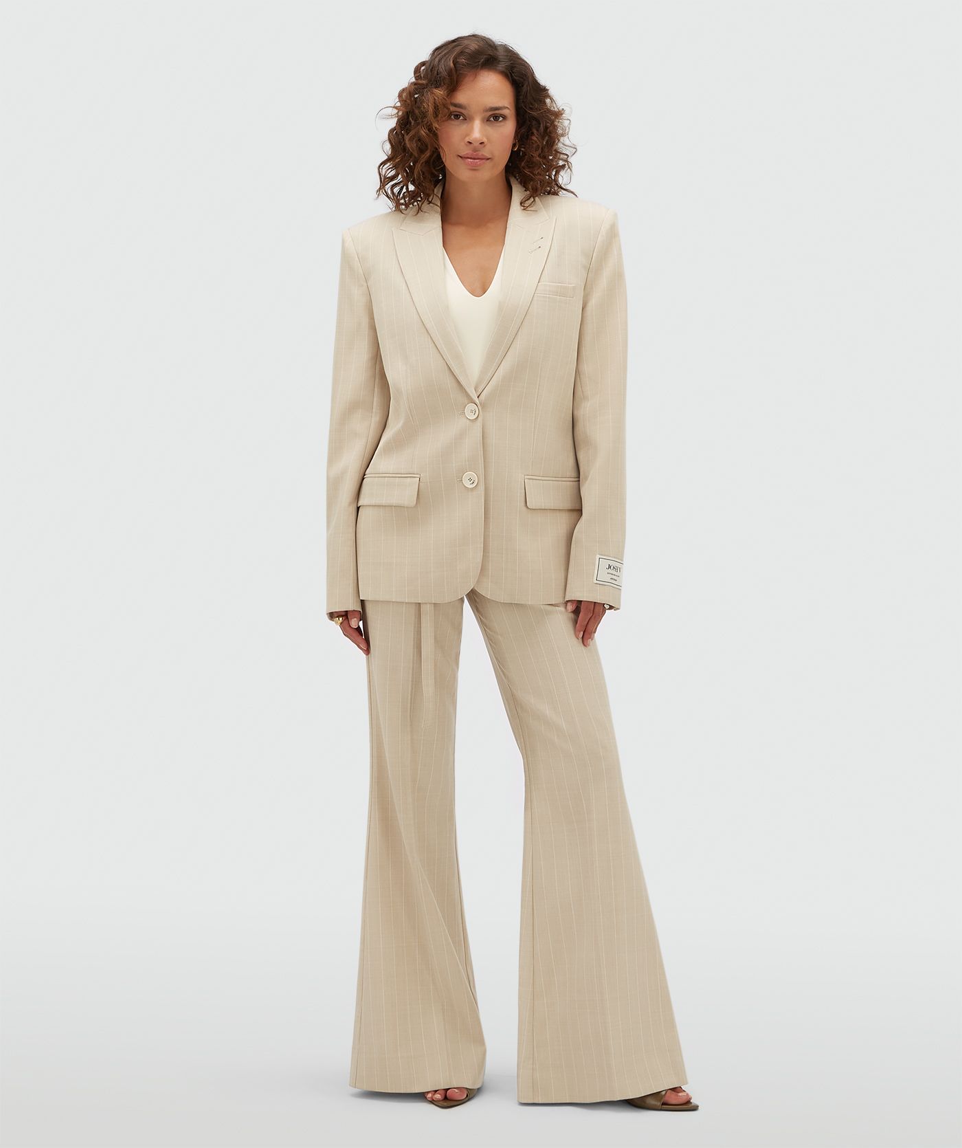 Model draagt een oversized beige blazer met krijtstreepje.
