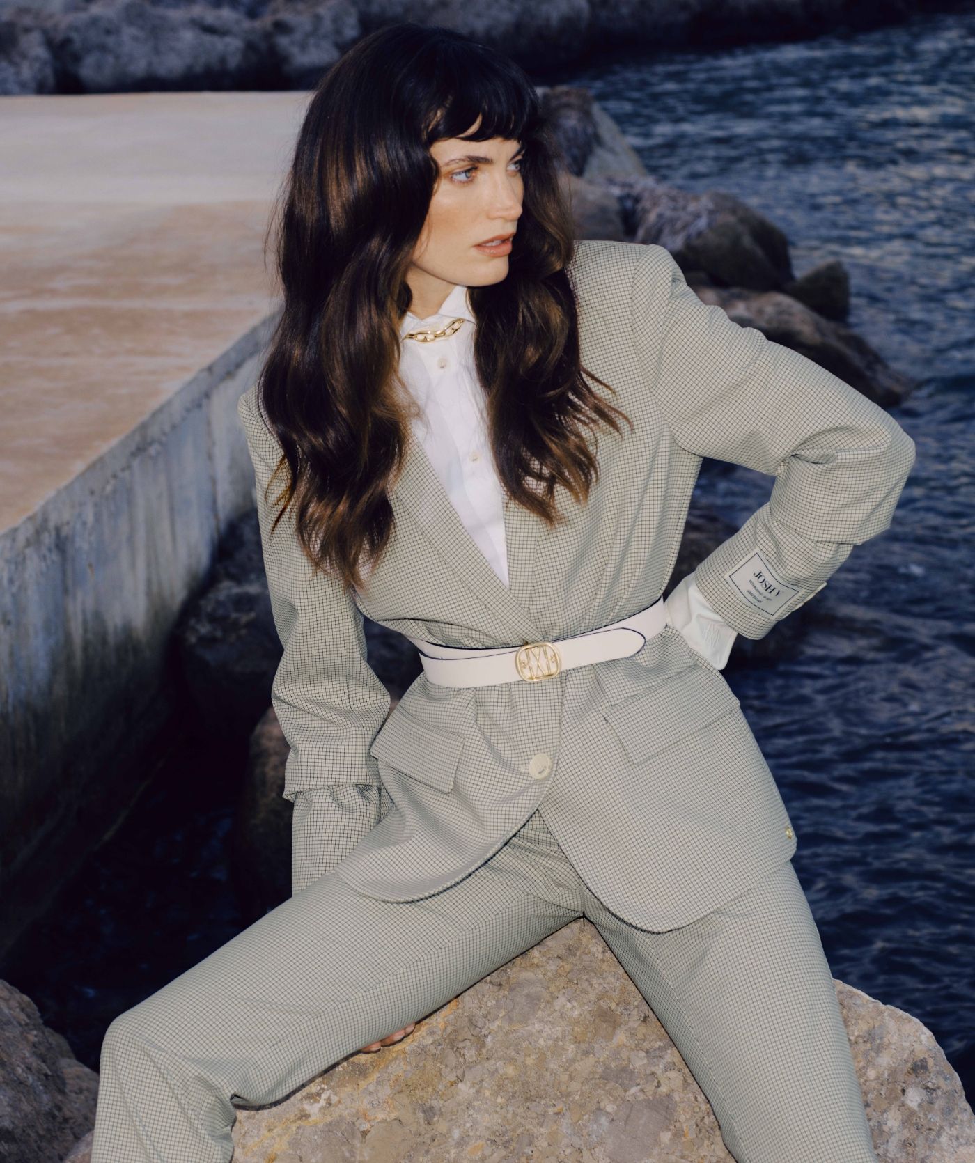 Het model draagt een oversized blazer in het Stone Check-patroon met het JOSH V-label op de mouw