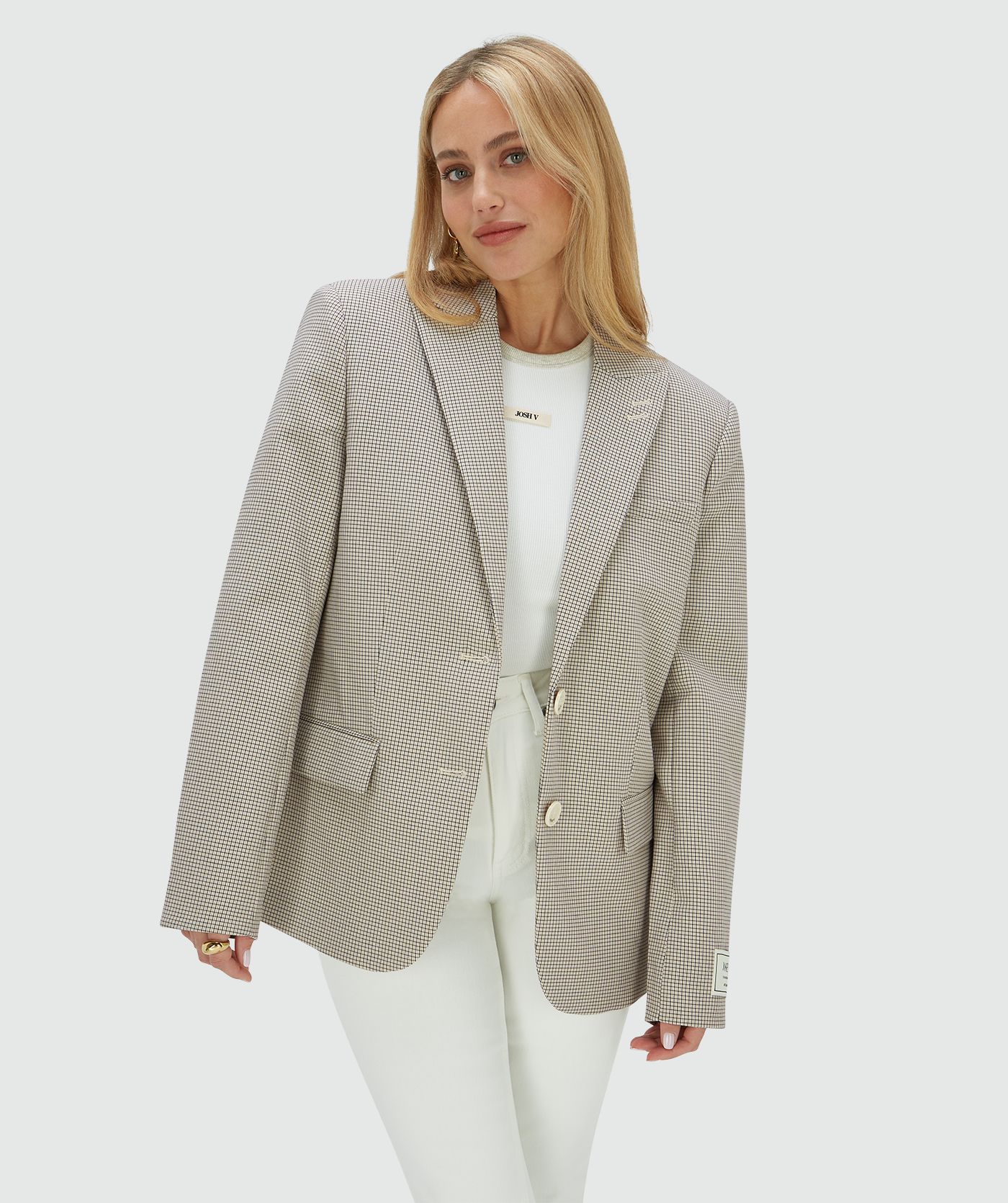 Het model draagt een oversized blazer in het Stone Check-patroon met het JOSH V-label op de mouw