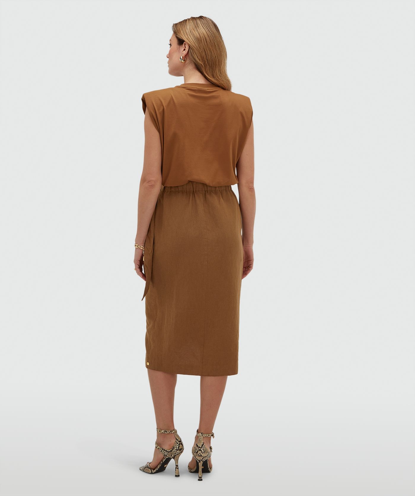 Achteraanzicht van een model in een overslagrok met striksluiting in de kleur Mocha Brown