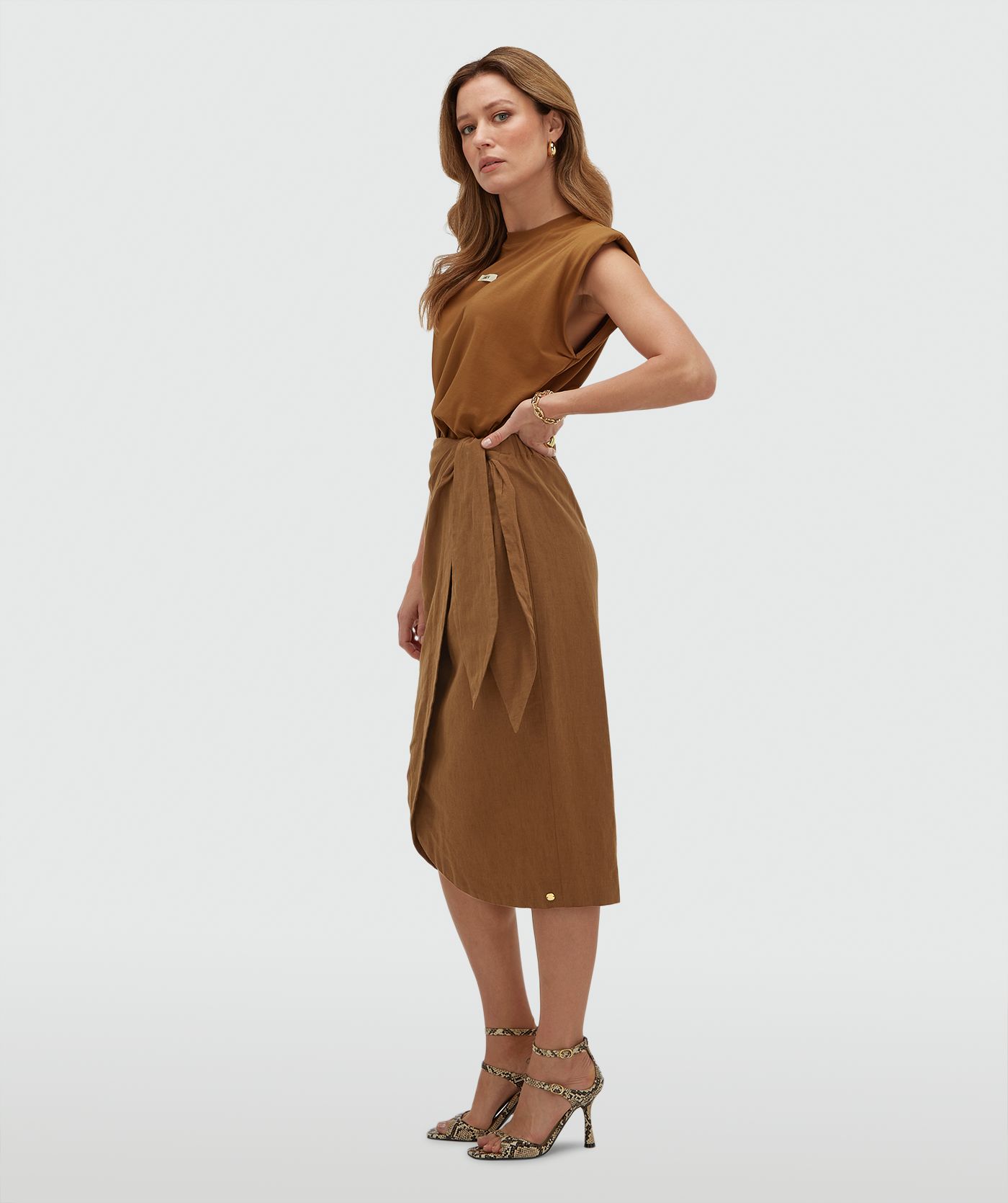Zijaanzicht van een model in een overslagrok met striksluiting in de kleur Mocha Brown