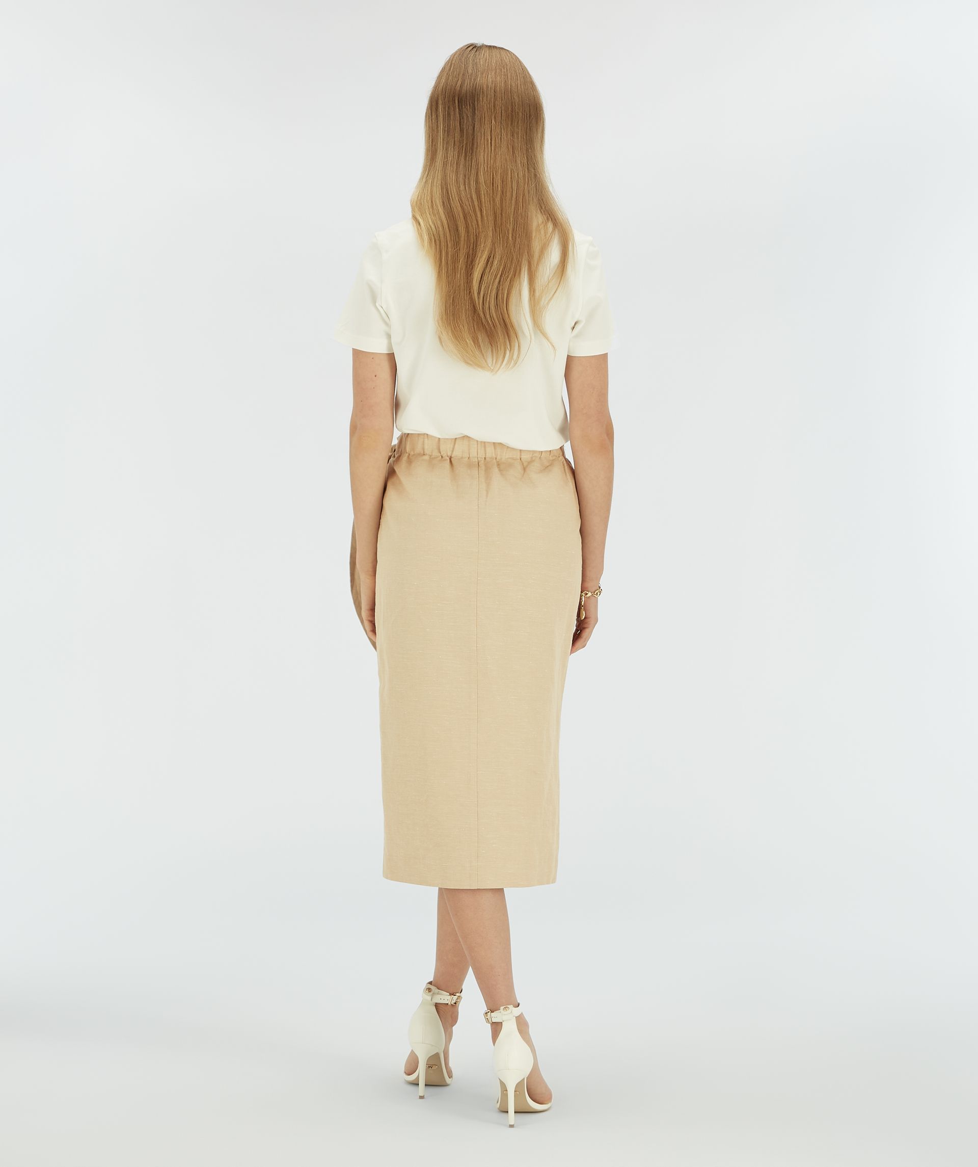 Achteraanzicht van een model in een beige overslagjurk.