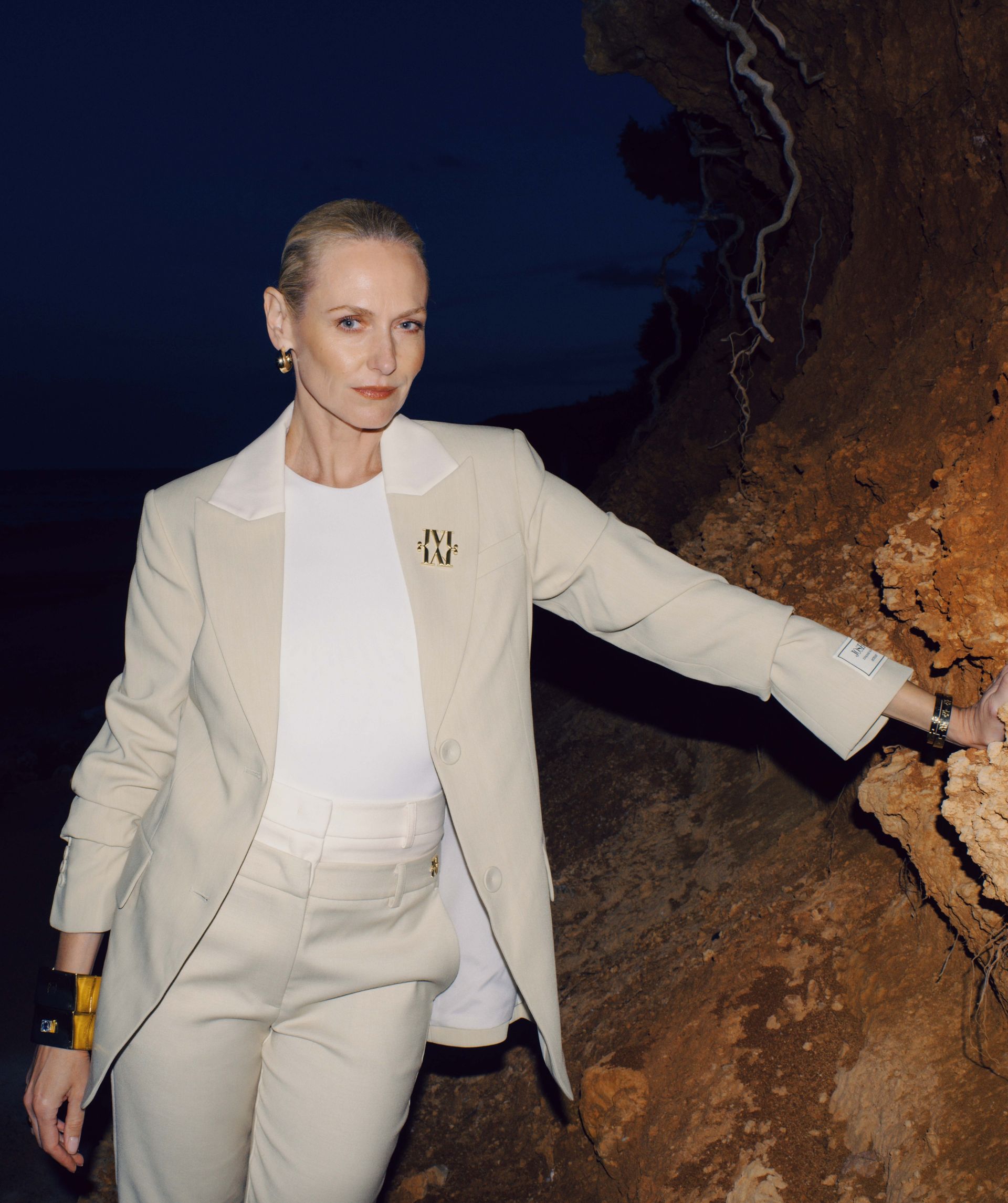 Het model draagt een fitted blazer in de kleur Ecru Melange, waarbij de kraag is uitgevoerd in ecru en de rest van de blazer in melange. Op de mouw is het JOSH V-label te zien