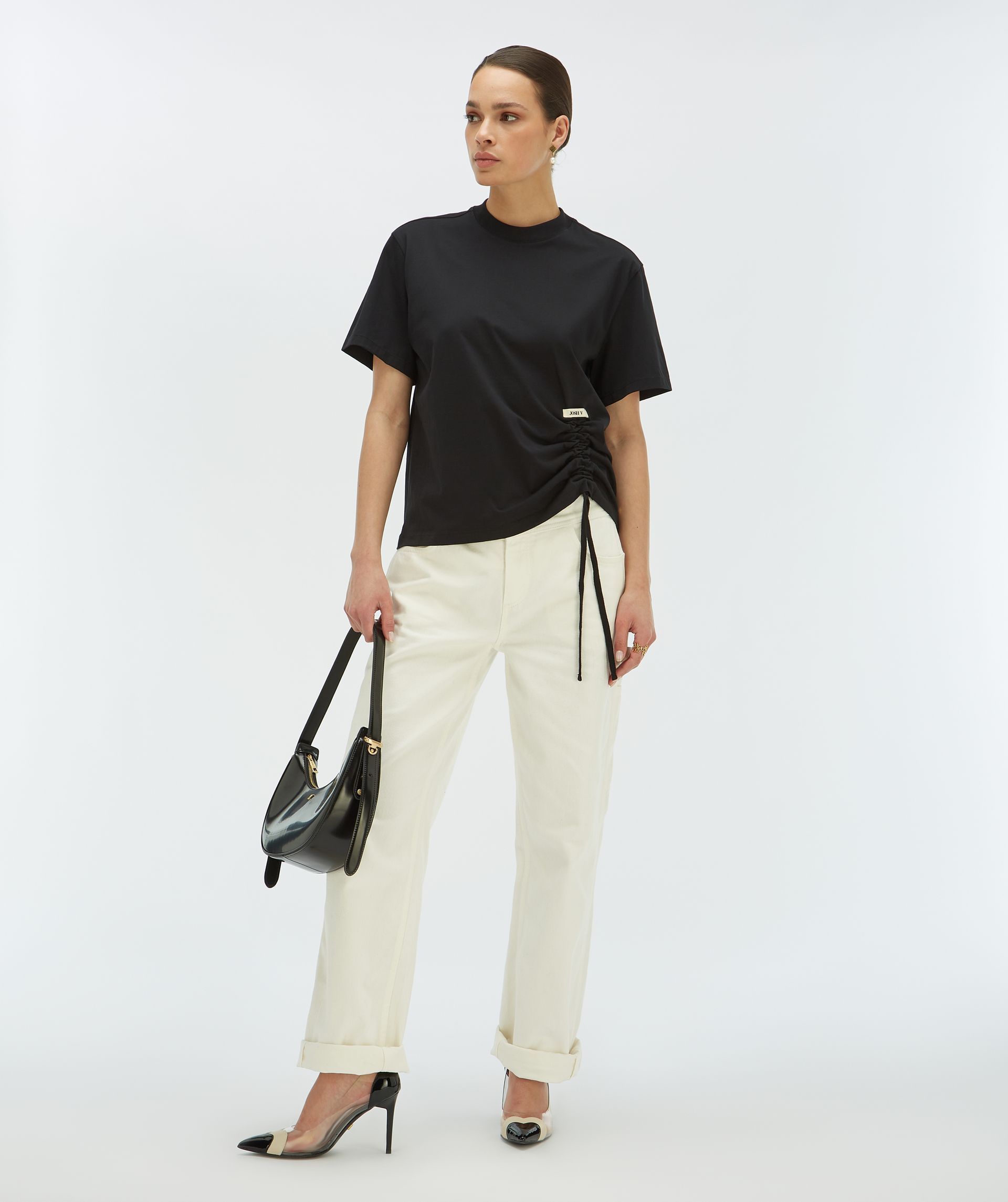 Model draagt een zwart regular fit T-shirt met een trekkoordaccent aan de linkeronderkant - Josh V.