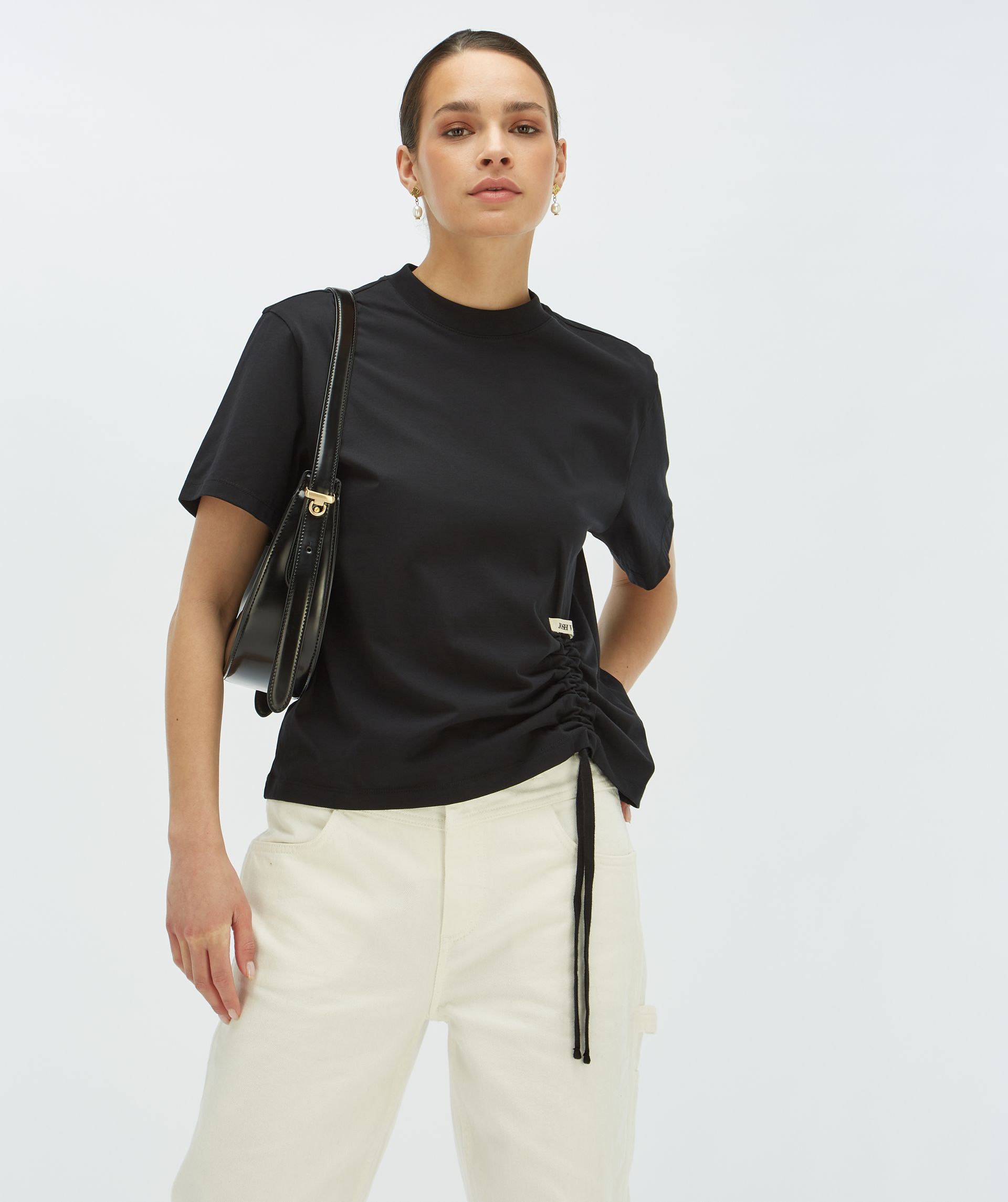 Model draagt een zwart regular fit T-shirt met een trekkoordaccent aan de linkeronderkant - Josh V.