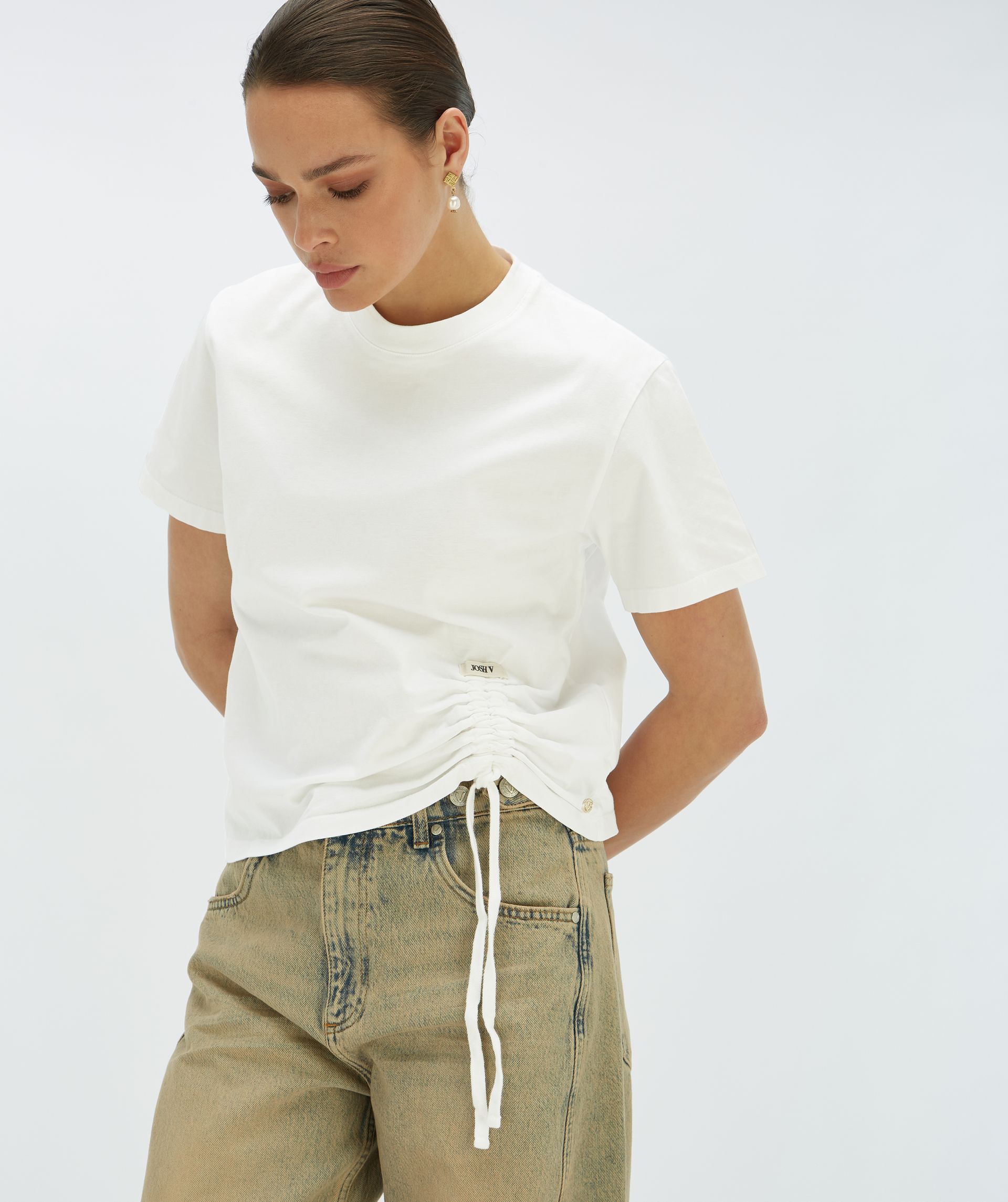 Model draagt een regular fit T-shirt met de linker onderkant een trekkoordaccent - Josh V.