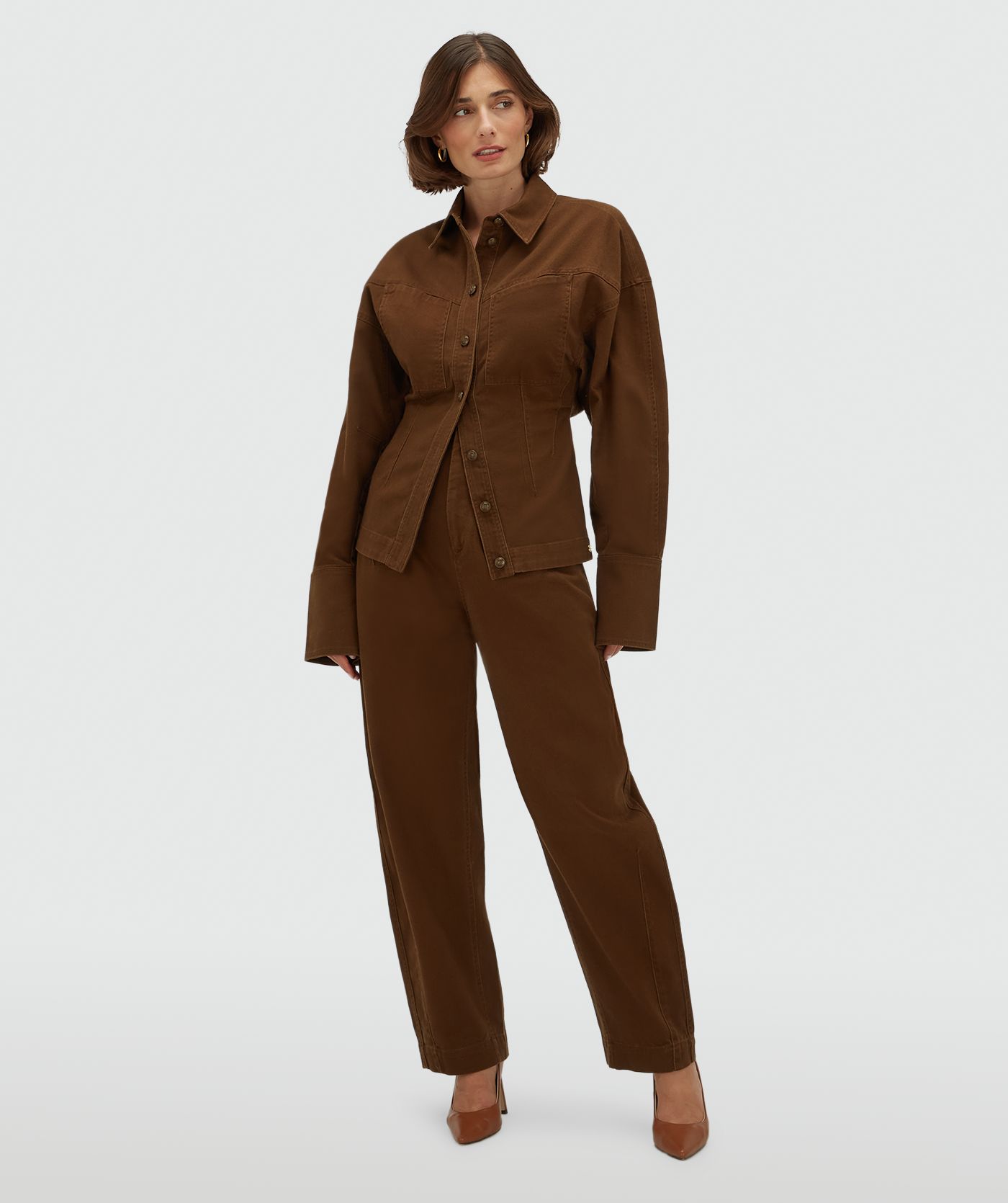 Model draagt een donkerbruine spijkerblouse met gecombineerd met de bijpassende broek.