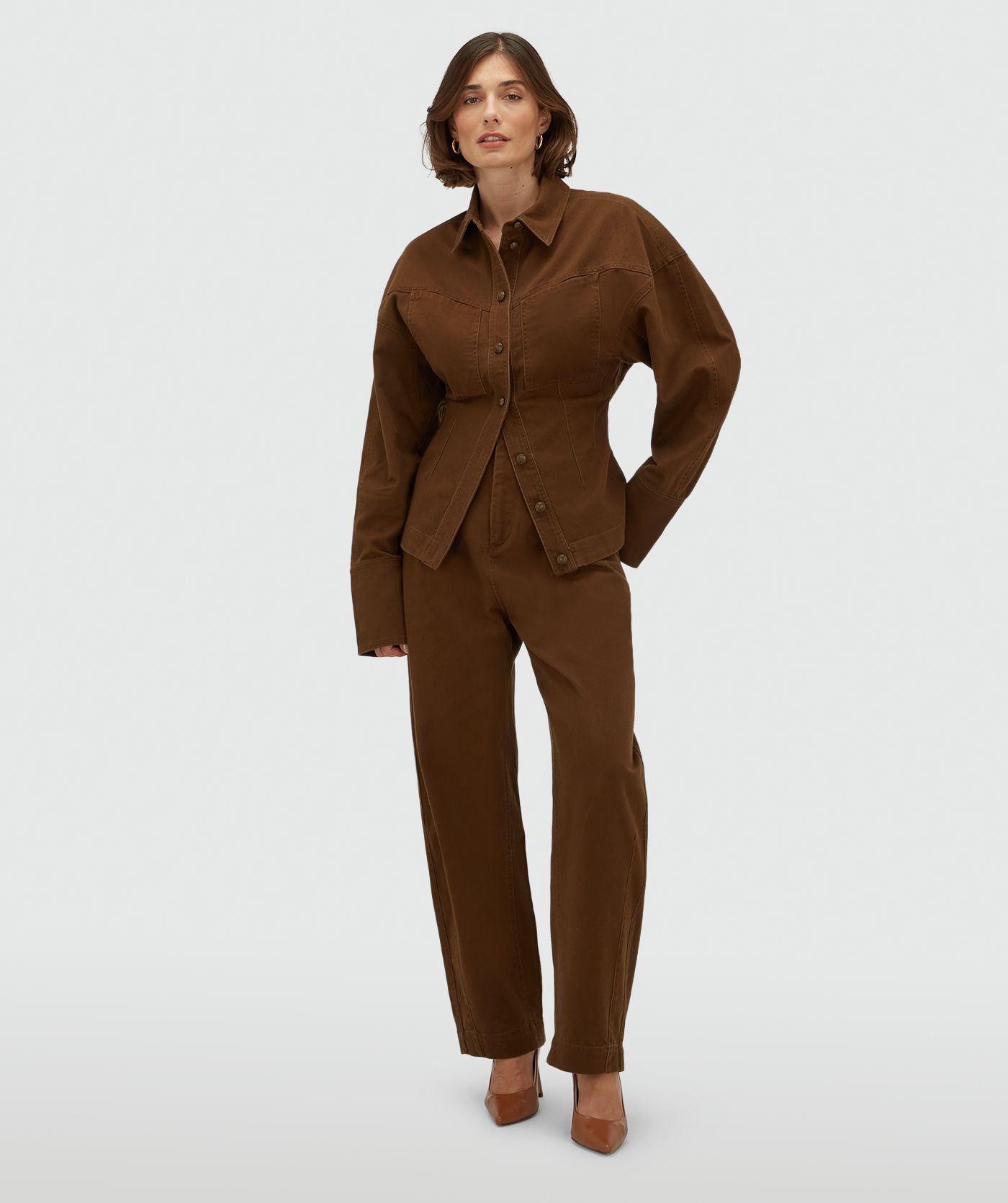 Model draagt een donkerbruine spijkerblouse met gecombineerd met de bijpassende broek.