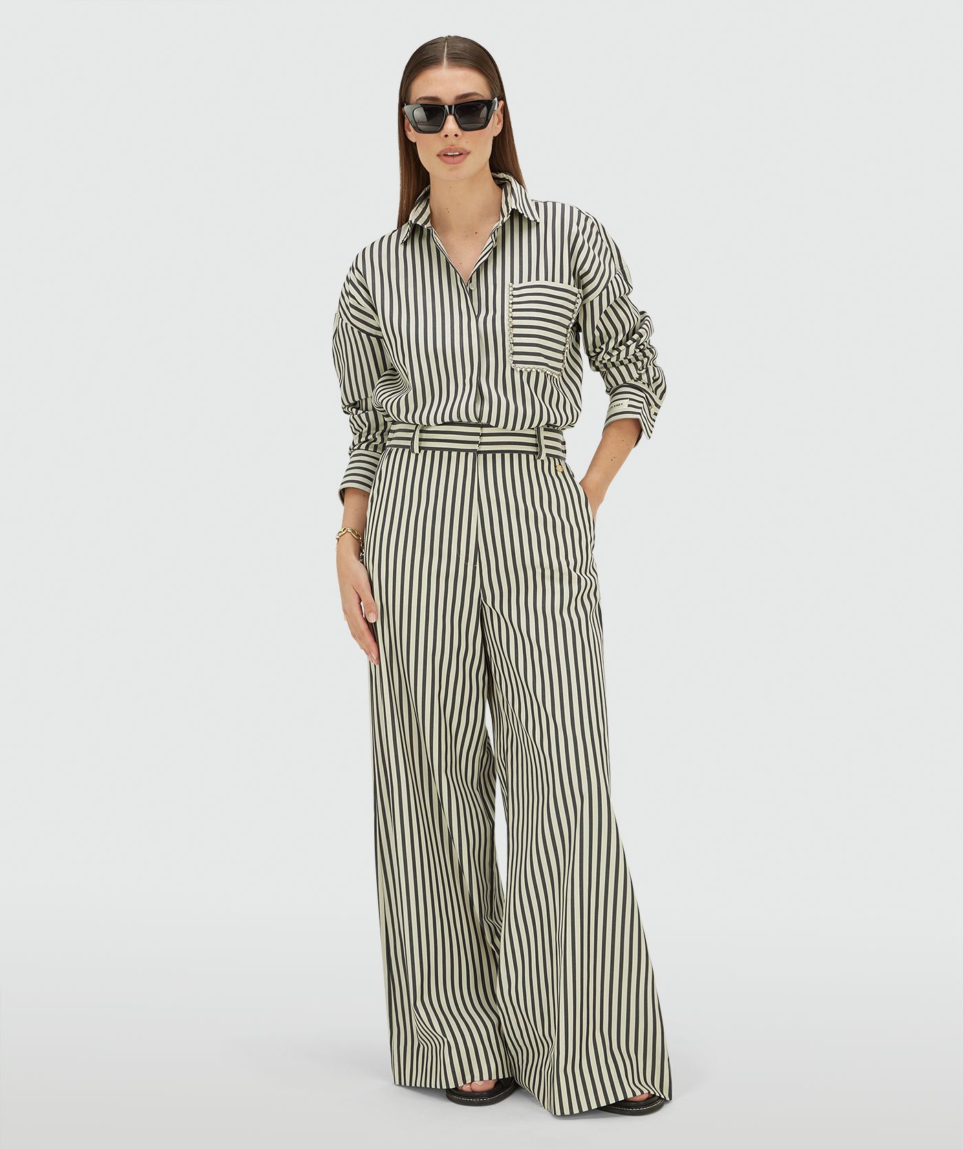 Model draagt een mid rise wide leg pantalon met strepen in de kleur Dark Blue Stripe