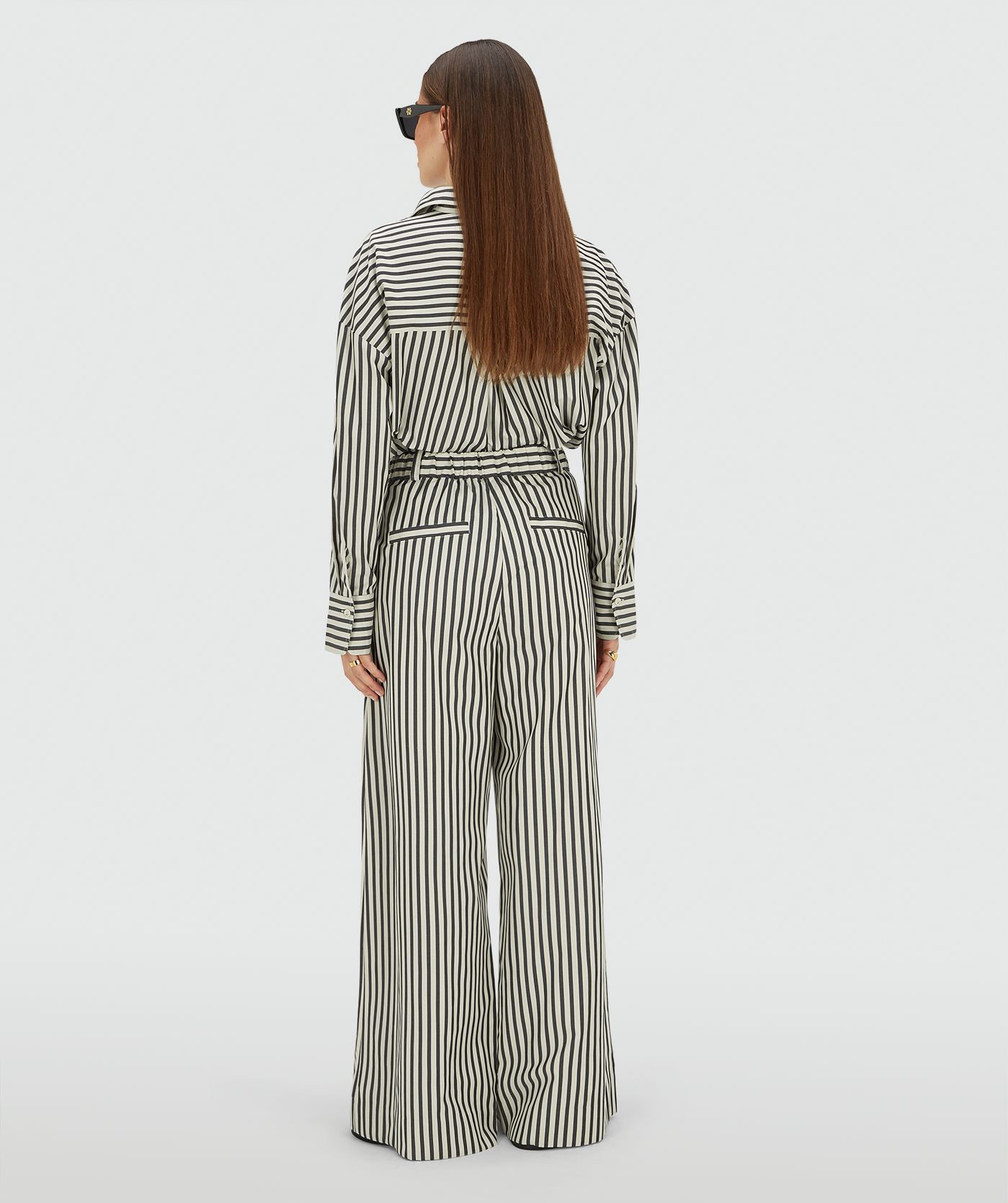 Achteraanzicht van een model in een mid rise wide leg pantalon met strepen in de kleur Dark Blue Stripe