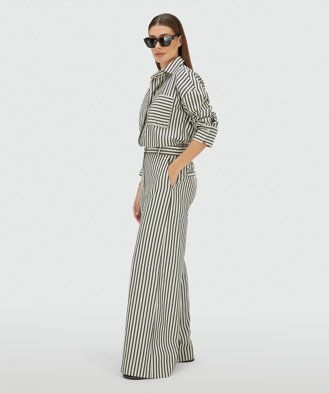 Zijaanzicht van een model in een mid rise wide leg pantalon met strepen in de kleur Dark Blue Stripe