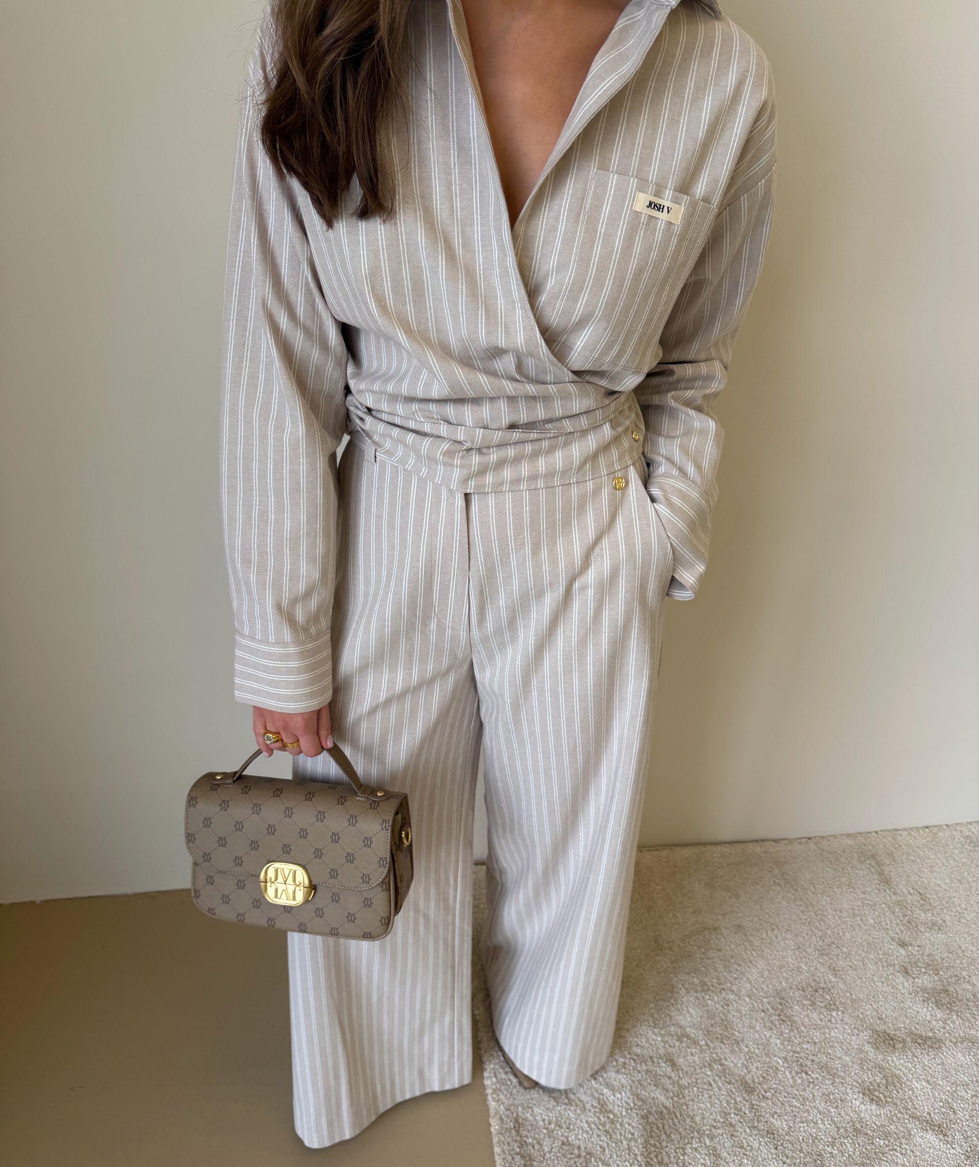 Model draagt een mid rise wide leg pantalon met strepen in de kleur Stone Stripe