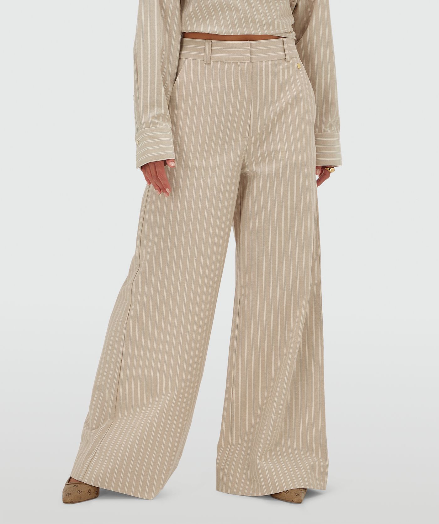 Model draagt een mid rise wide leg pantalon met strepen in de kleur Stone Stripe