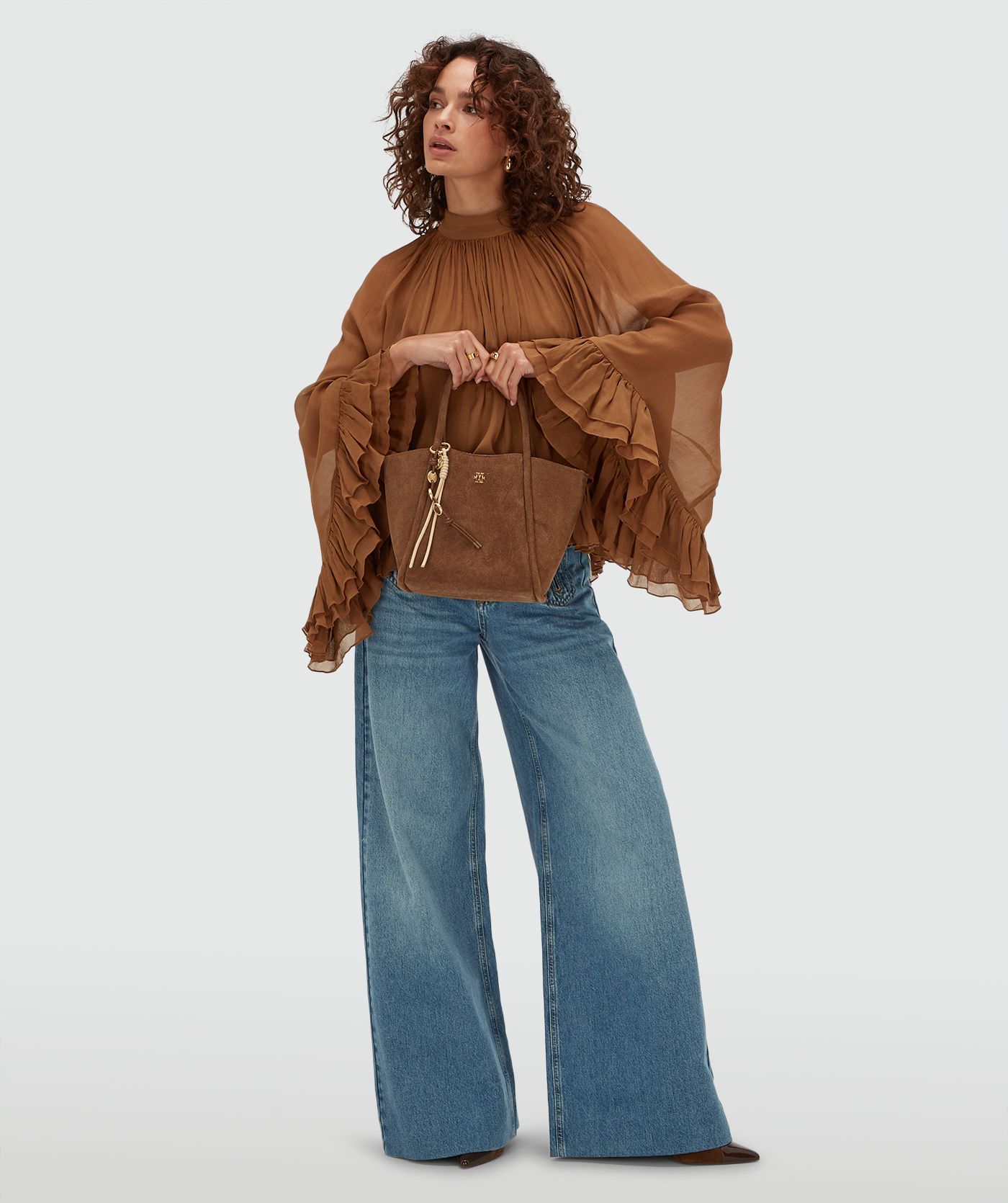 Model draagt een oversized top met ruffle details in de kleur Mocha Brown