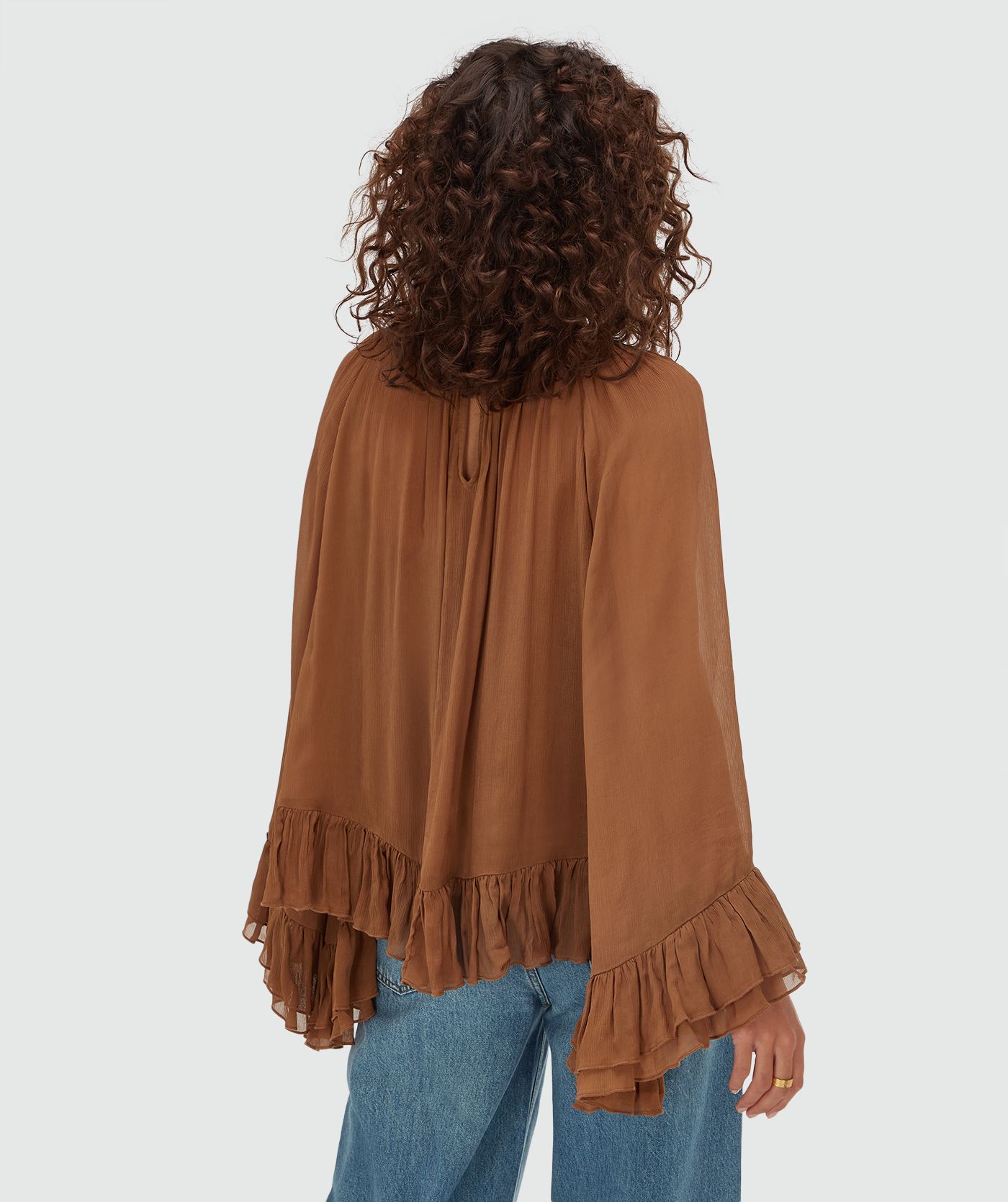 Achterzijde van een model in een oversized top met ruffle details in de kleur Mocha Brown