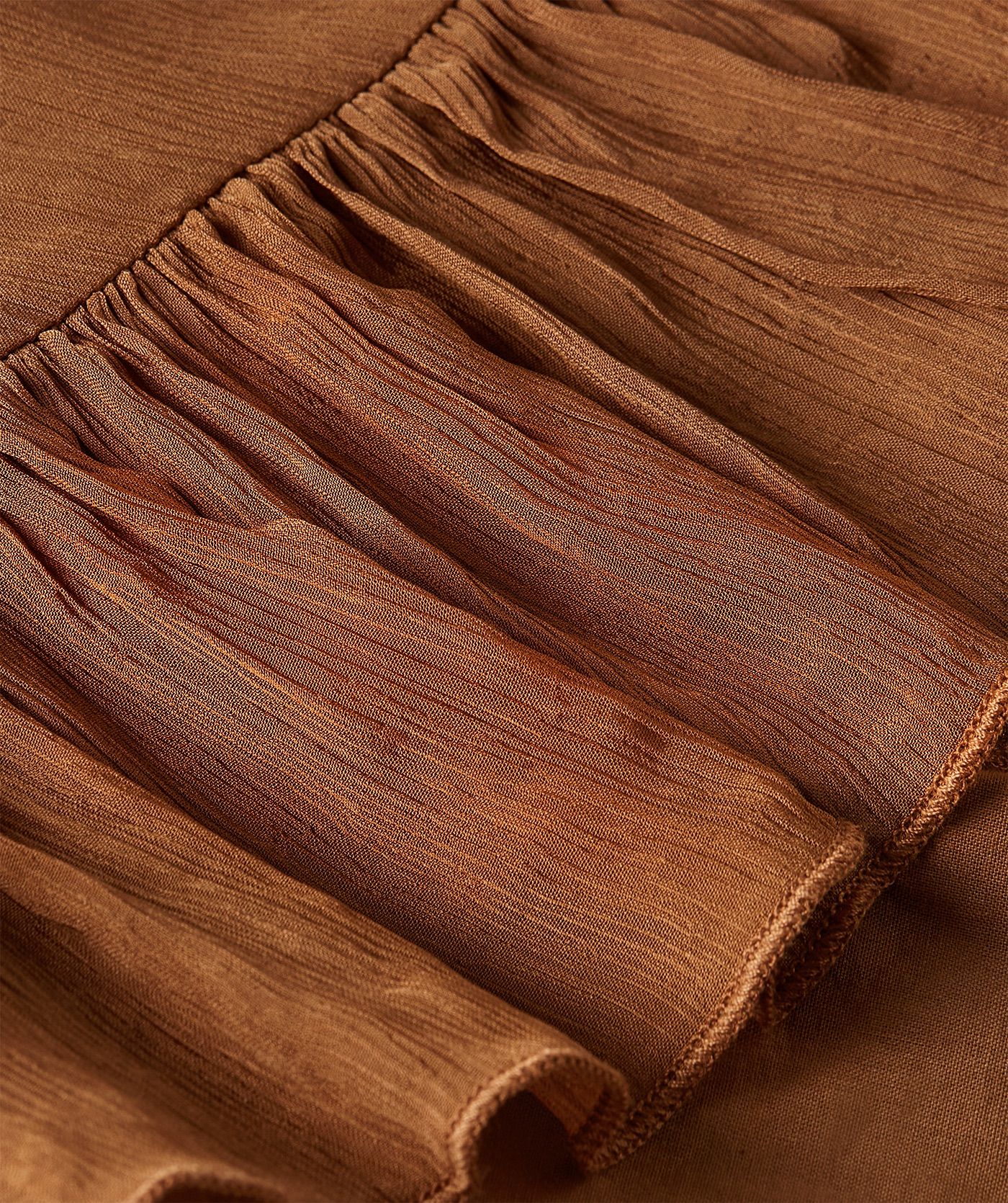 Close-up van een oversized top met ruffle details in de kleur Mocha Brown