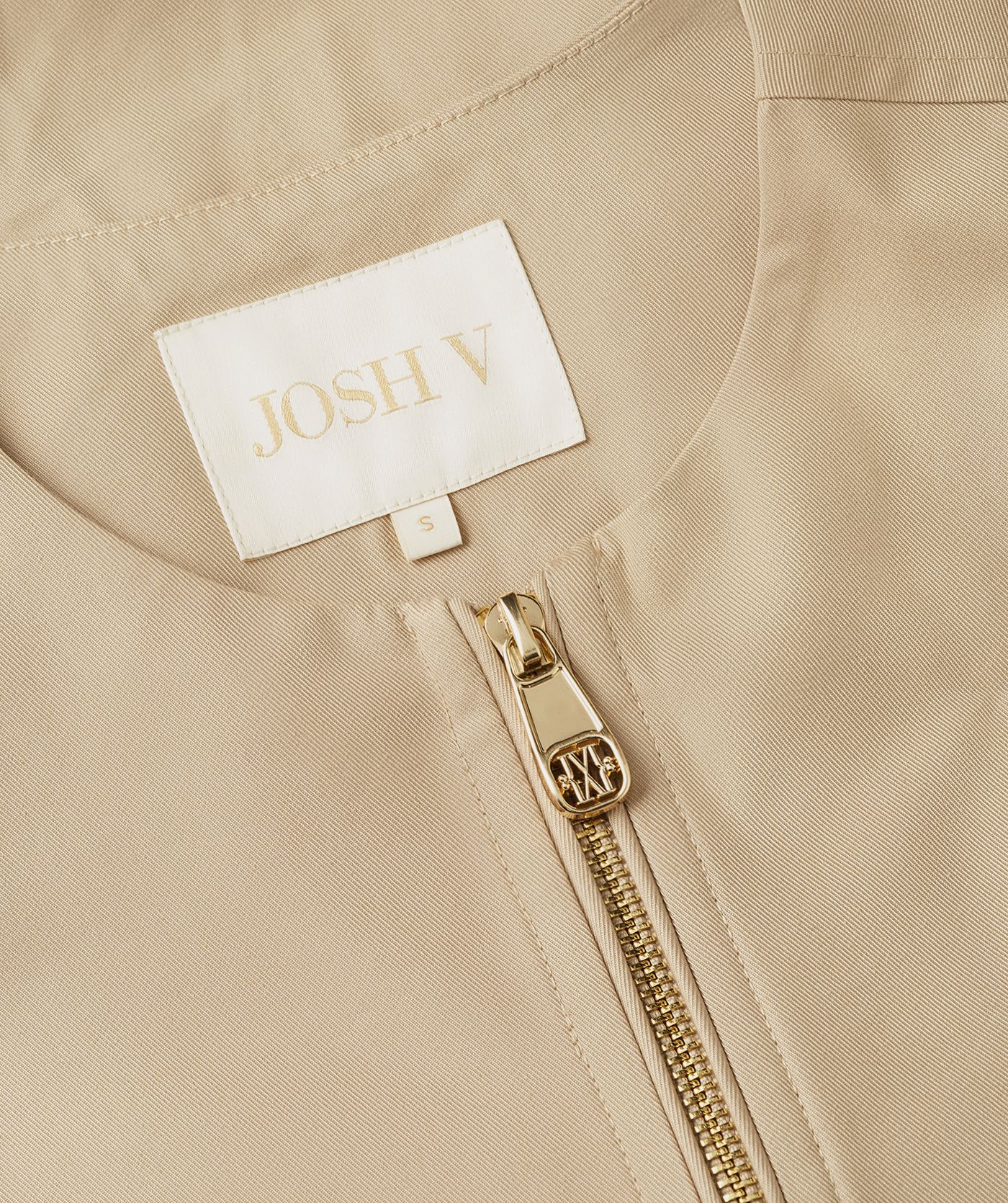 Close-up van de halslijn van de beige gilet.