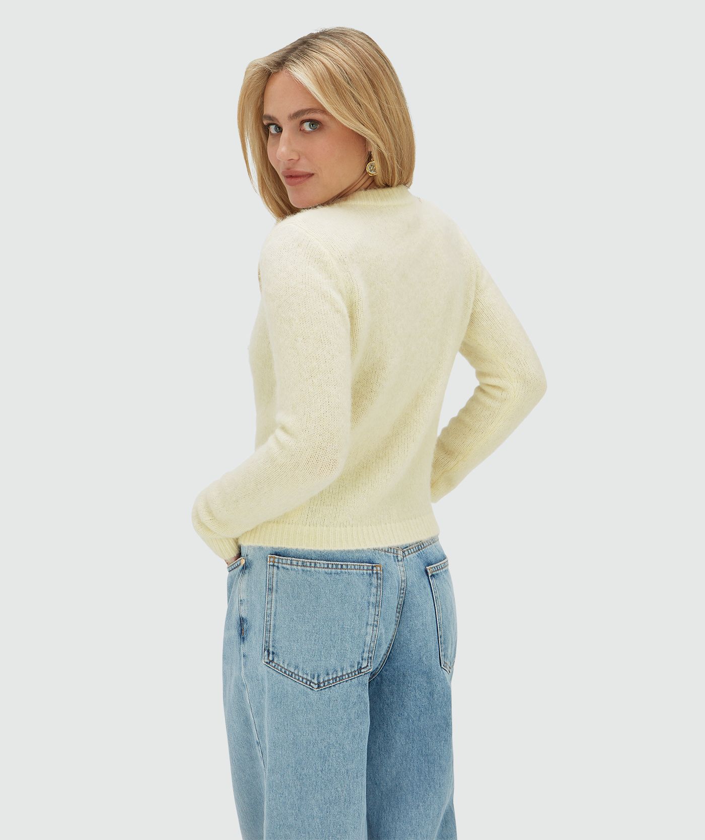 Achteraanzicht van het model in een vest met een regular fit, uitgevoerd in de kleur Butter Yellow