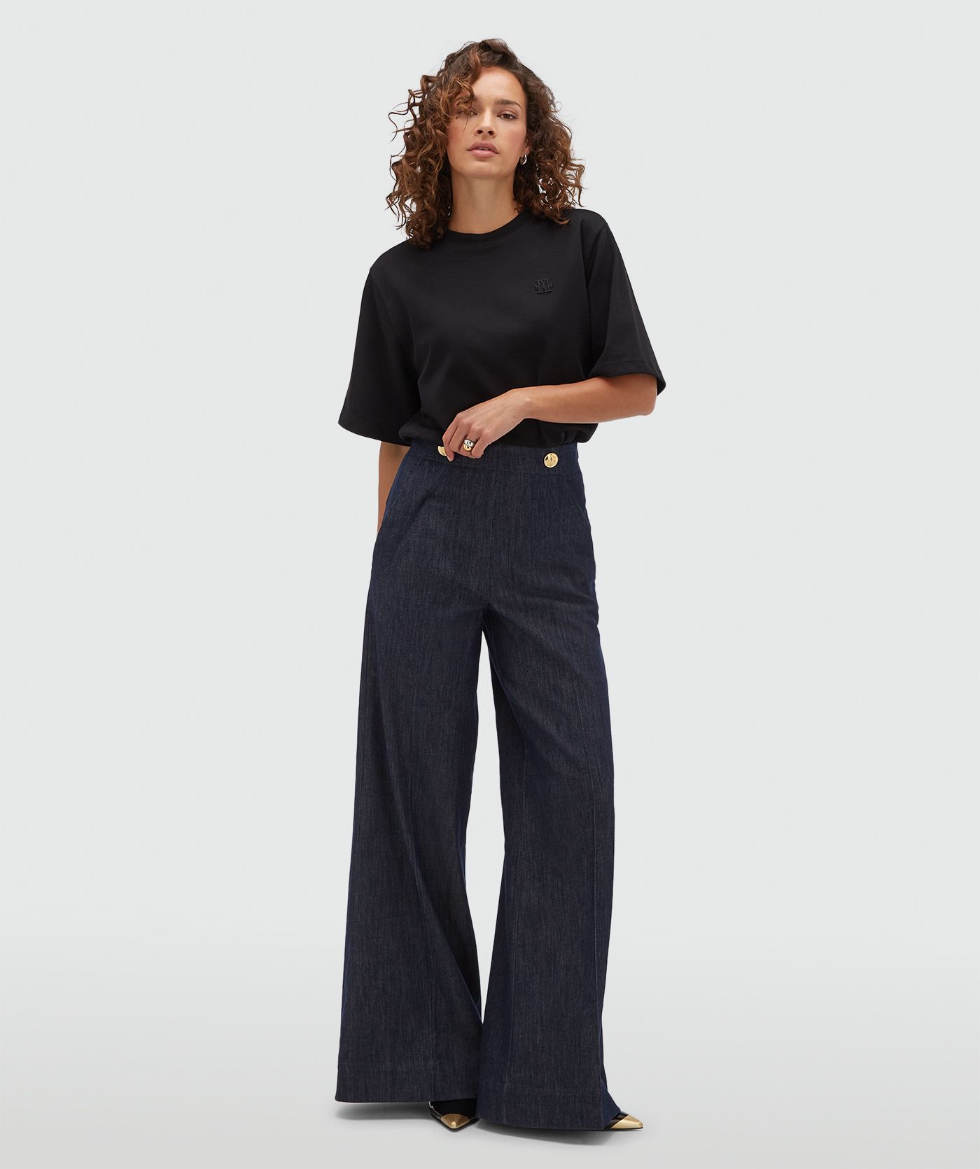 Model draagt een oversized zwart T-shirt.