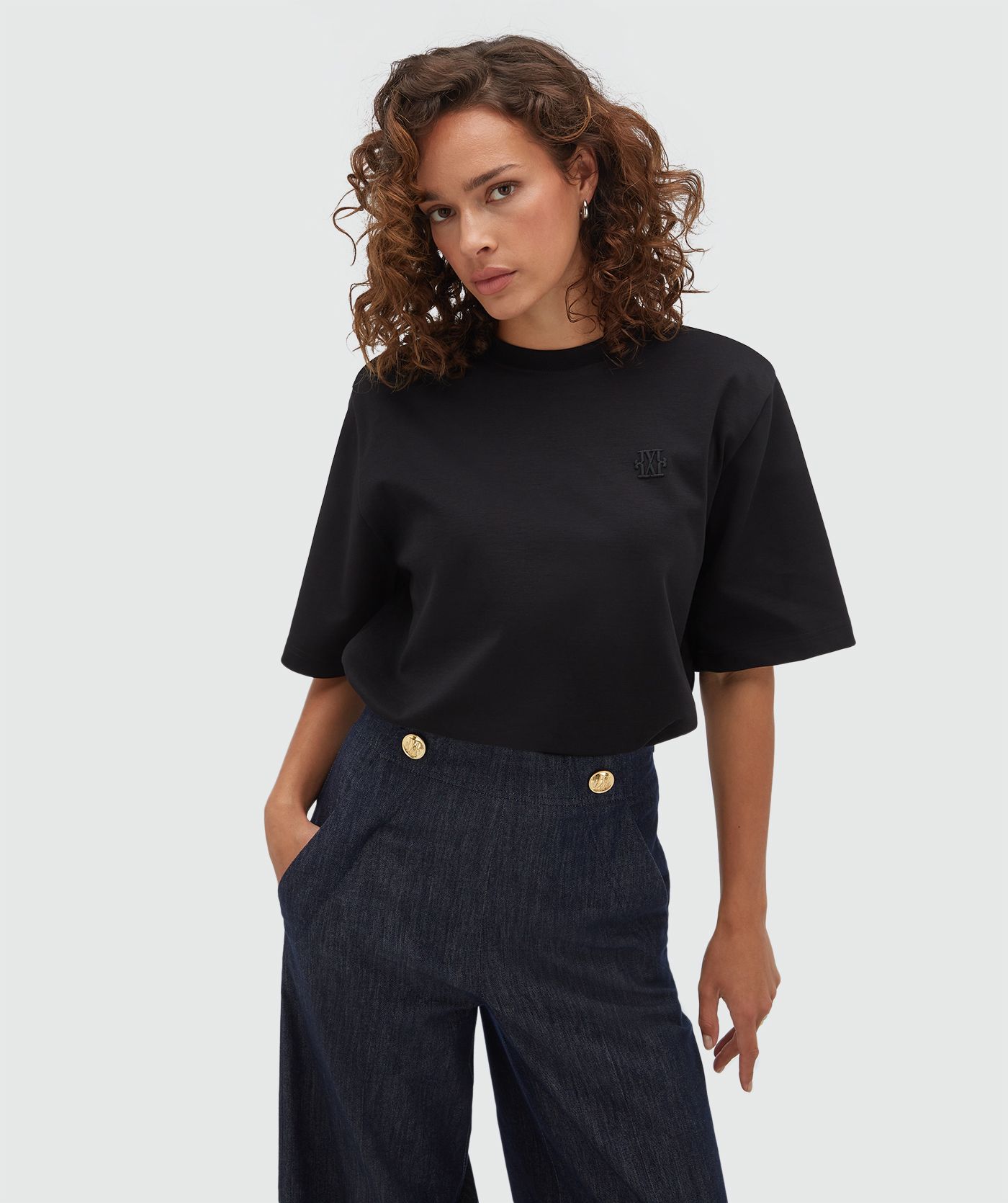 Model draagt een oversized zwart T-shirt.