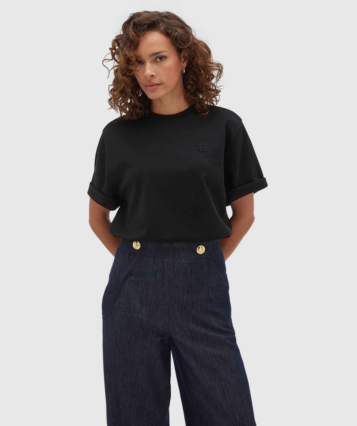 Model draagt een oversized zwart T-shirt.