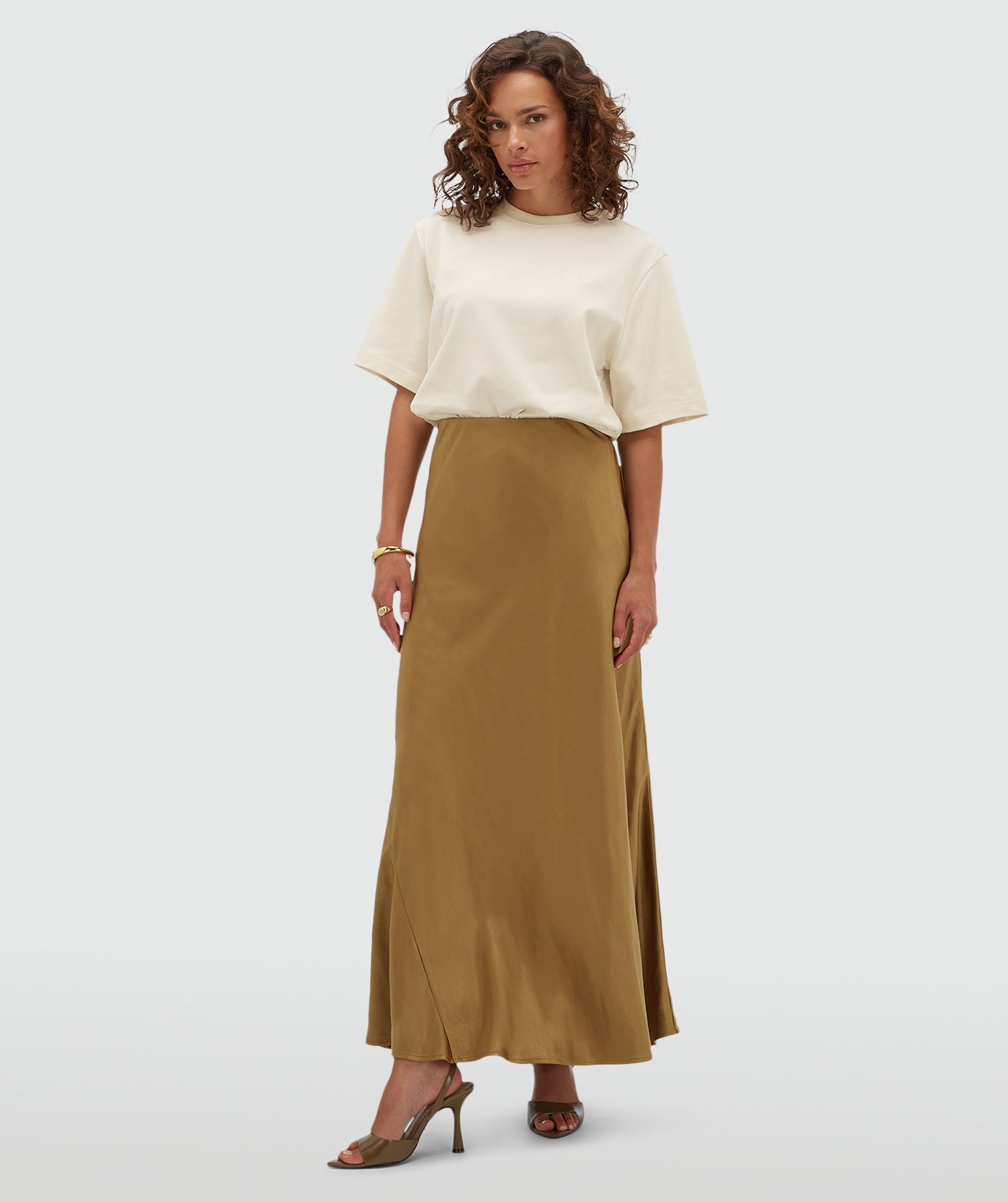 Het model draagt een creme T-shirt. 