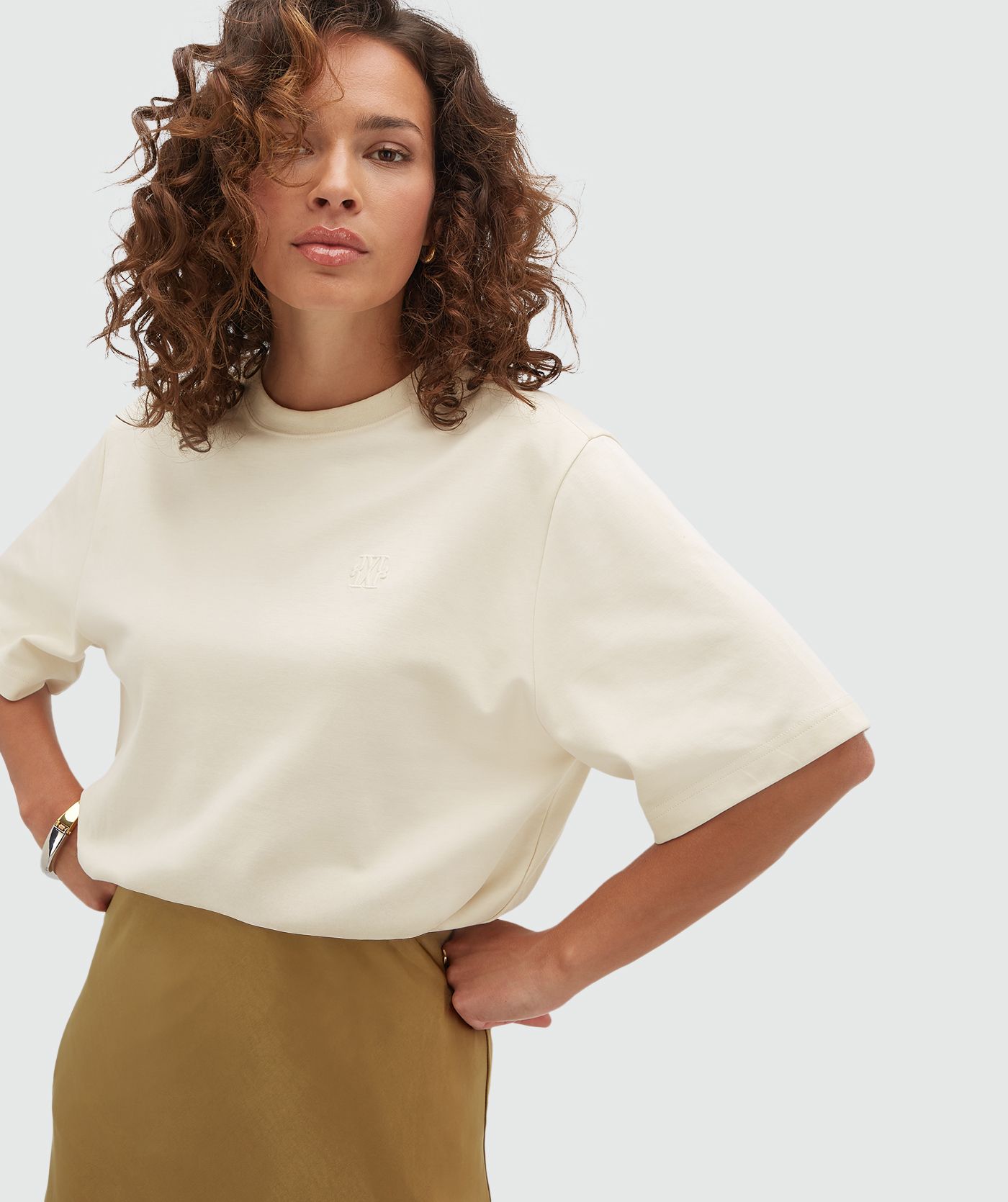 Het model draagt een creme T-shirt. 