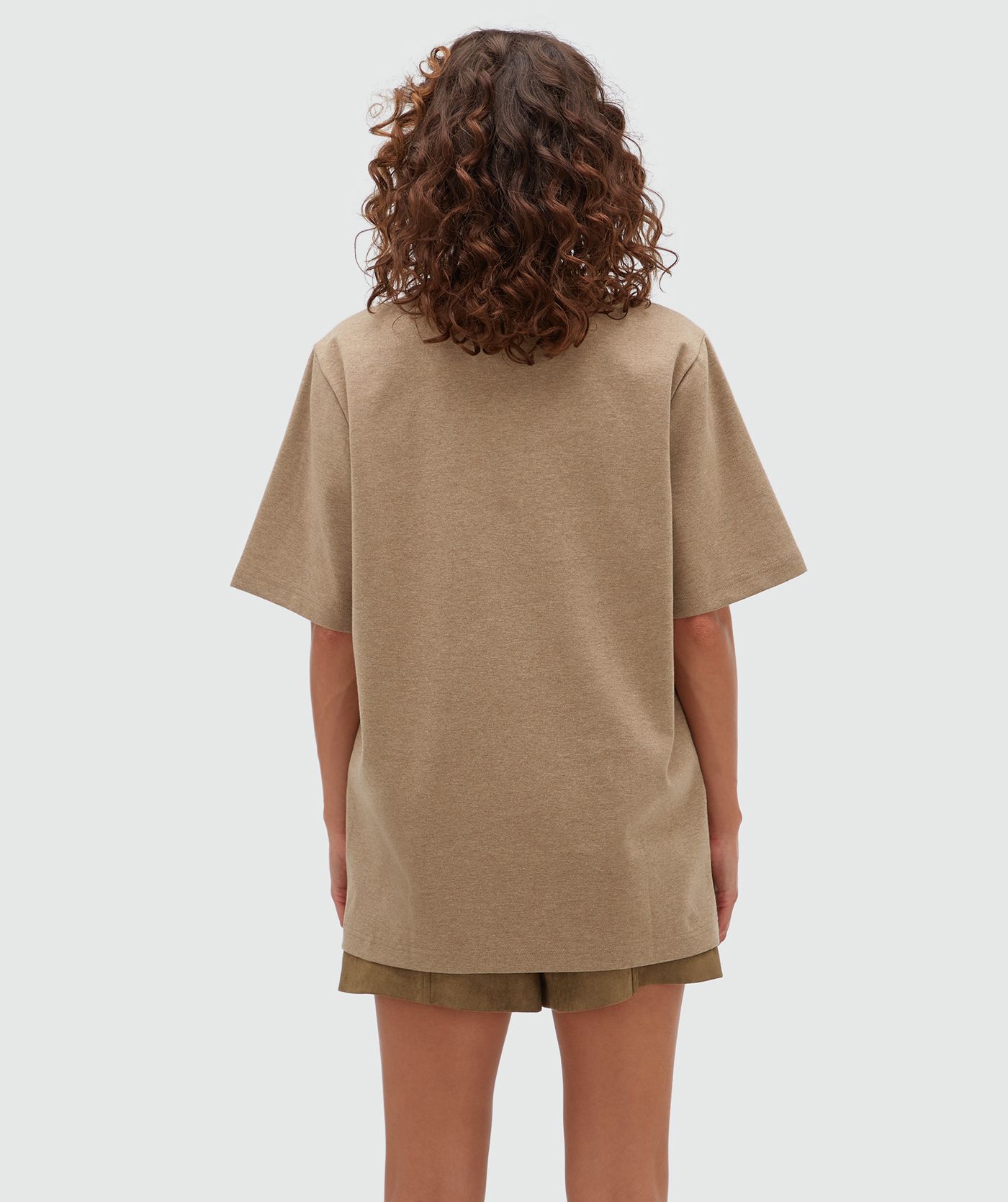 Achteraanzicht van een model in een bruine T-shirt.