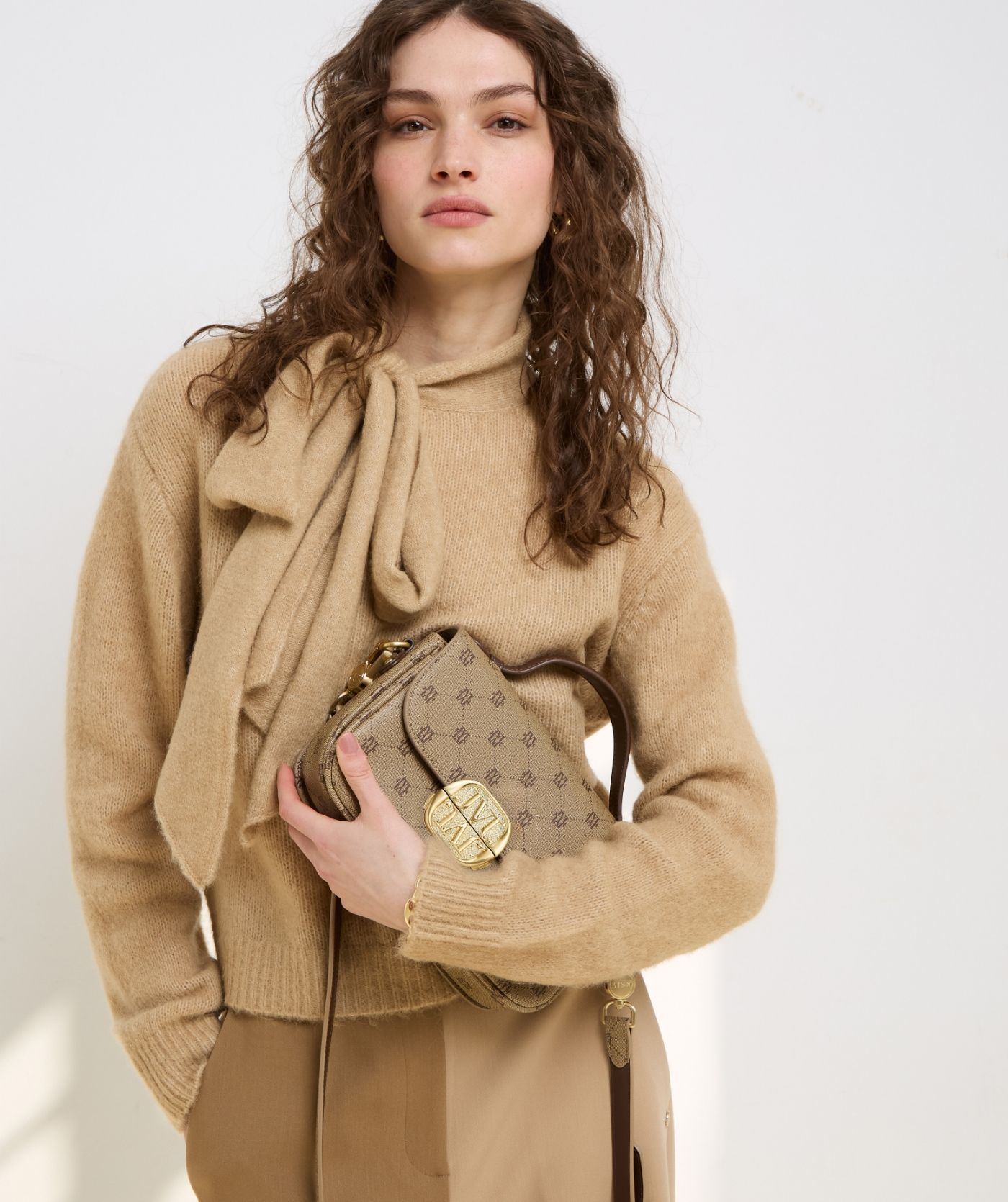 Model draagt een light brown melange regular fit trui met strikdetail bij de hals - Josh V