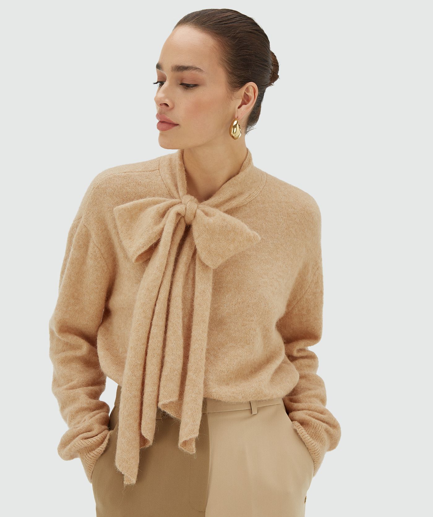 Model draagt een light brown melange regular fit trui met strikdetail bij de hals - Josh V