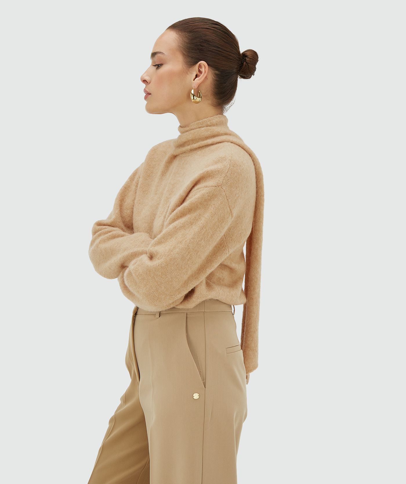 Zijaanzicht van een model in een light brown melange regular fit trui met strikdetail bij de hals - Josh V