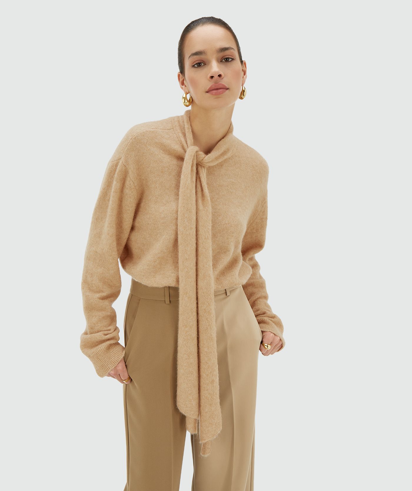 Model draagt een light brown melange regular fit trui met strikdetail bij de hals - Josh V