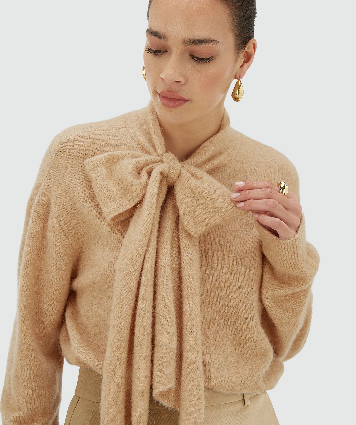 Model draagt een light brown melange regular fit trui met strikdetail bij de hals - Josh V