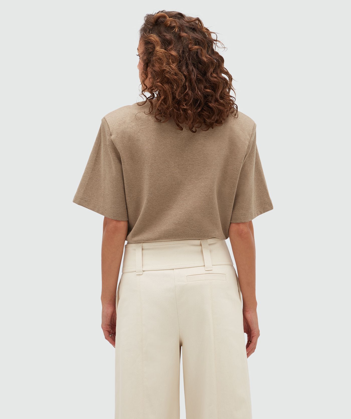 Achteraanzicht van een model in een bruine T-shirt body.