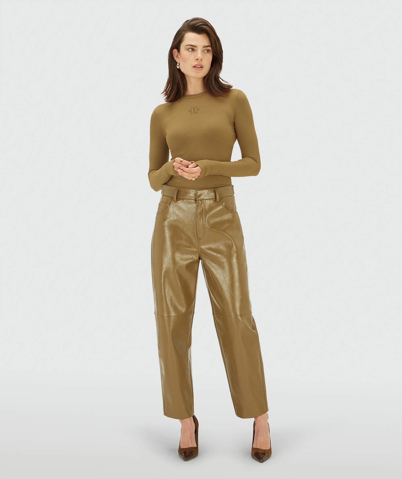 Model draagt een Olive Green mid waisted lacque broek met rechte pijpen