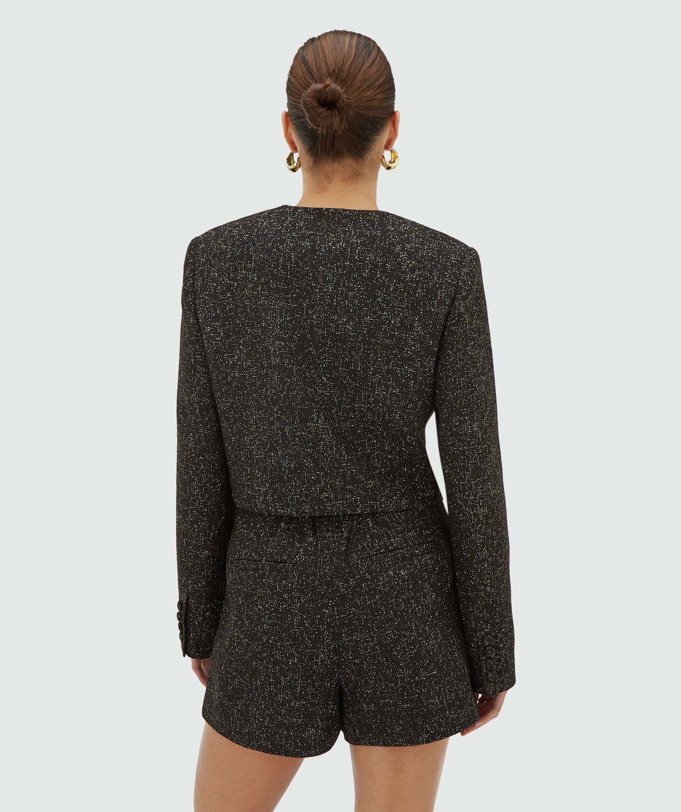 Achteraanzicht model in een blazer in zwart met goud- en zilverkleurig lurexdraad - JOSH V
