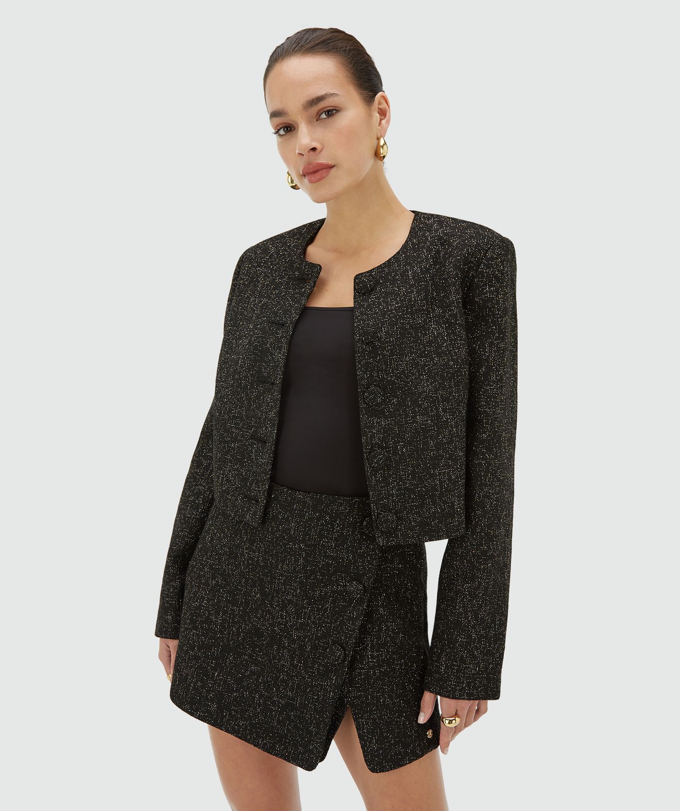 Model draagt een blazer in zwart met goud- en zilverkleurig lurexdraad - JOSH V