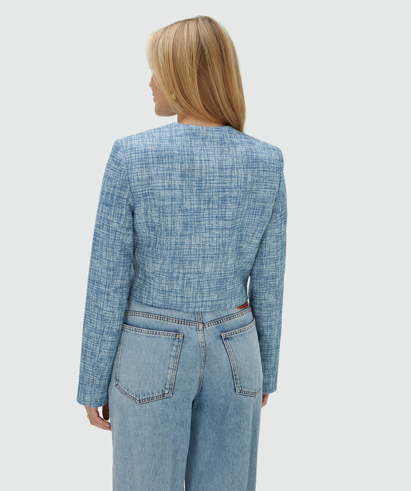 Achteraanzicht van een model in een cropped blazer met lurex, uitgevoerd in de kleur Blue Bouclé