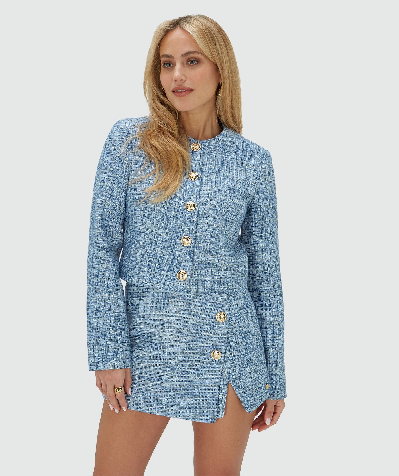 Model draagt een cropped blazer met lurex, uitgevoerd in de kleur Blue Bouclé